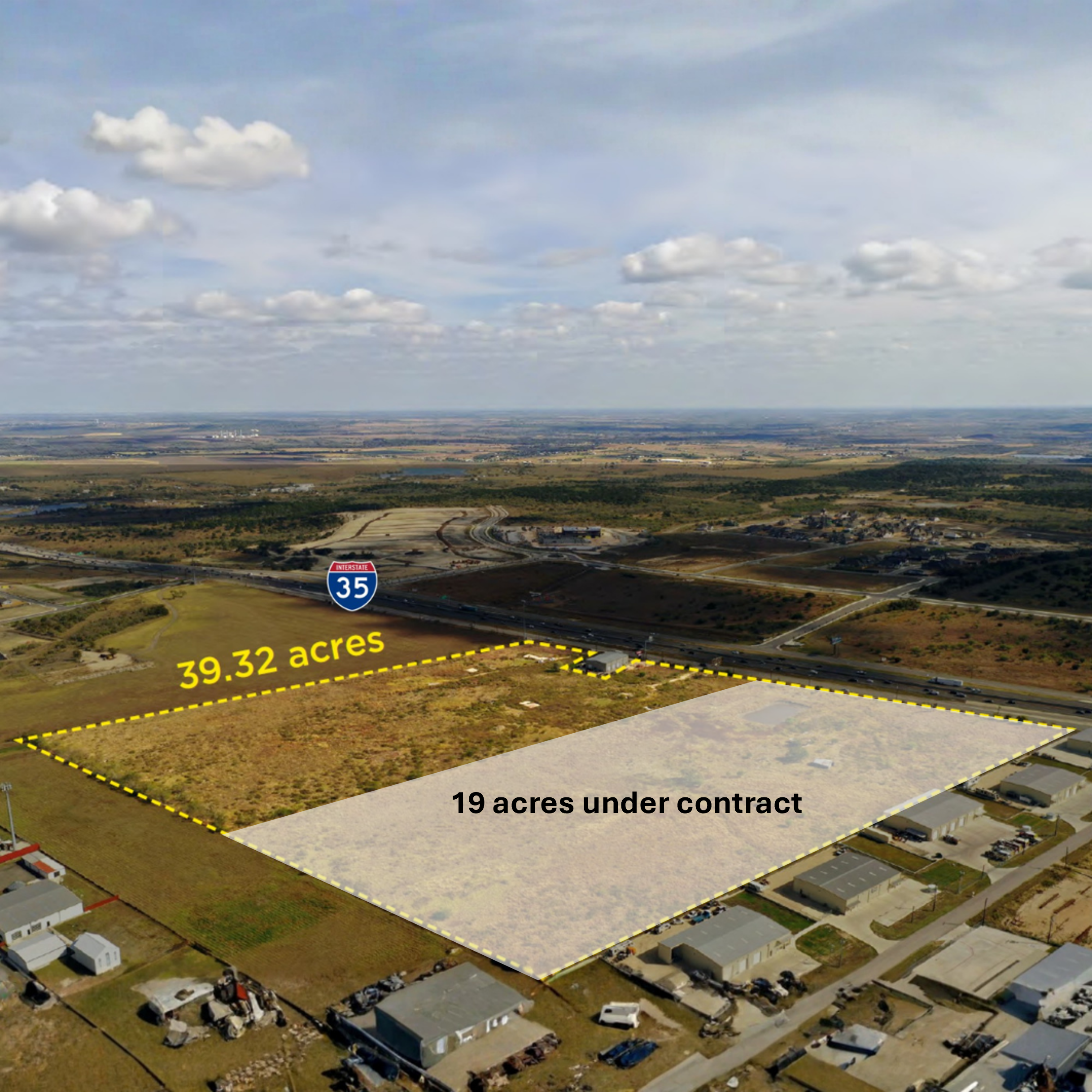 Aerial view of an open land parcel outlined in yellow, labeled as 39.32 acres, adjacent to a highway with a smaller parcel of 19 acres under contract nearby, with residential houses, roads, and a blue Interstate 35 sign visible.
