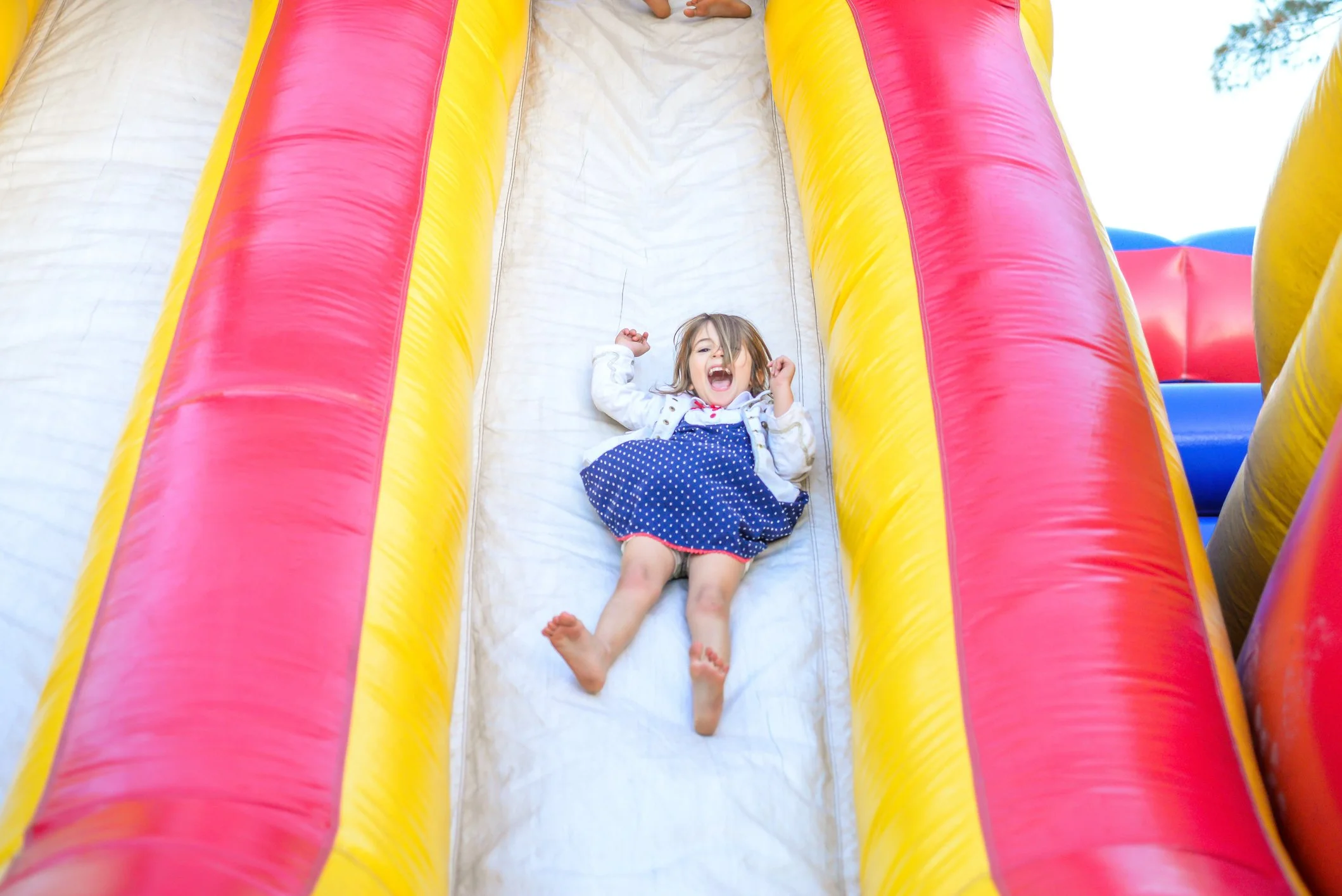 A young knoxville kid playing sliding at the playful pop up market kids zone inflatable slide at Kids Care