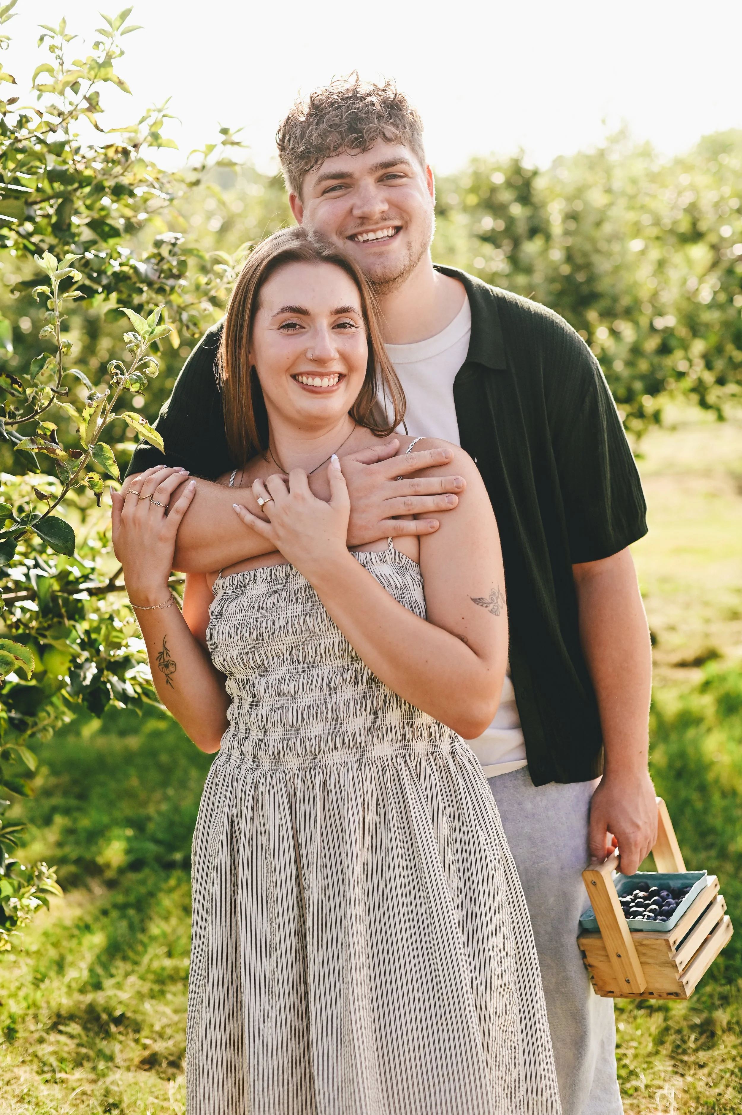 a couple holding fresh picked blueberries after their surprise proposal
