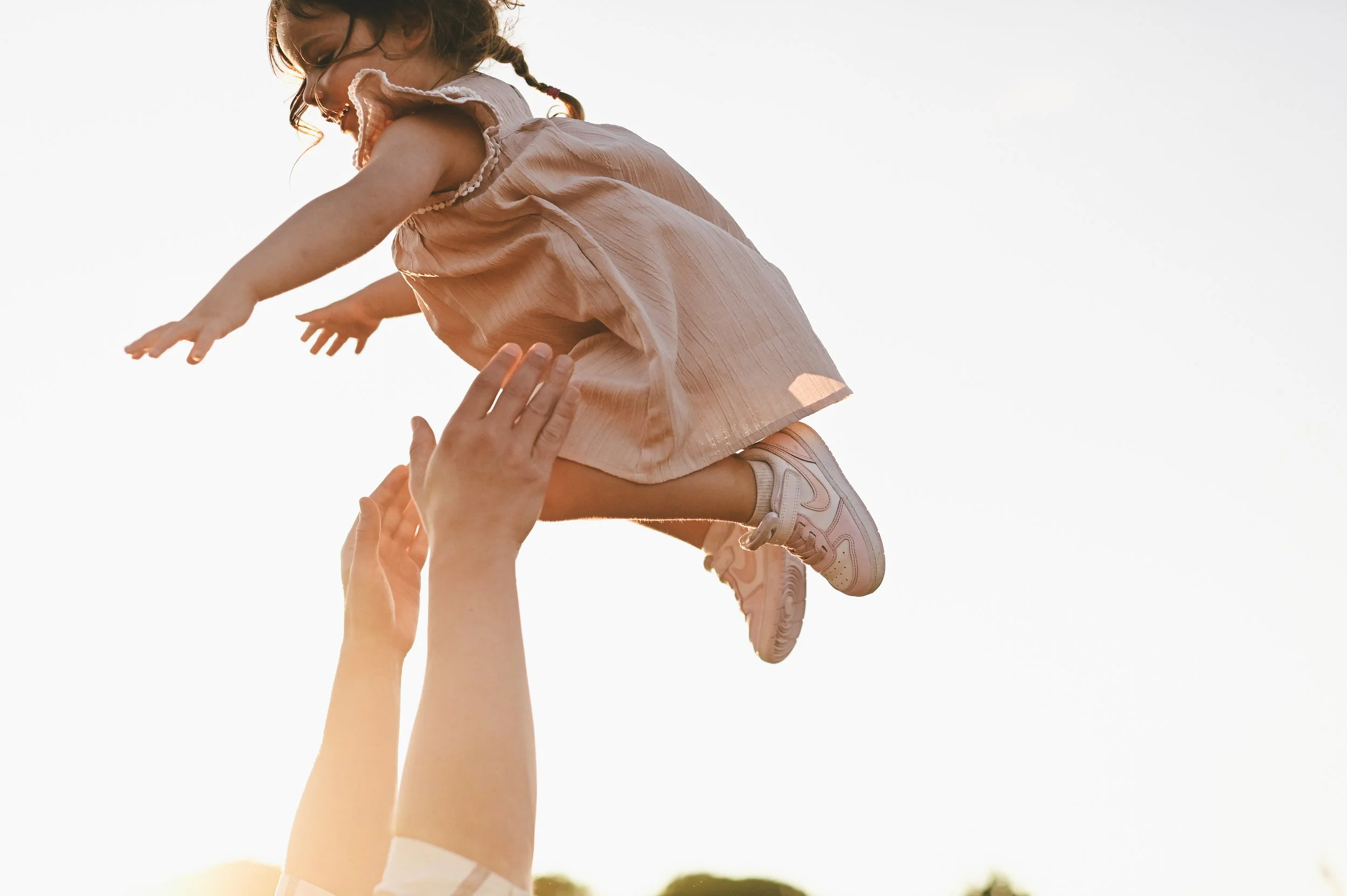 Toddler being tossed in the air during a Portland area family session in Maine