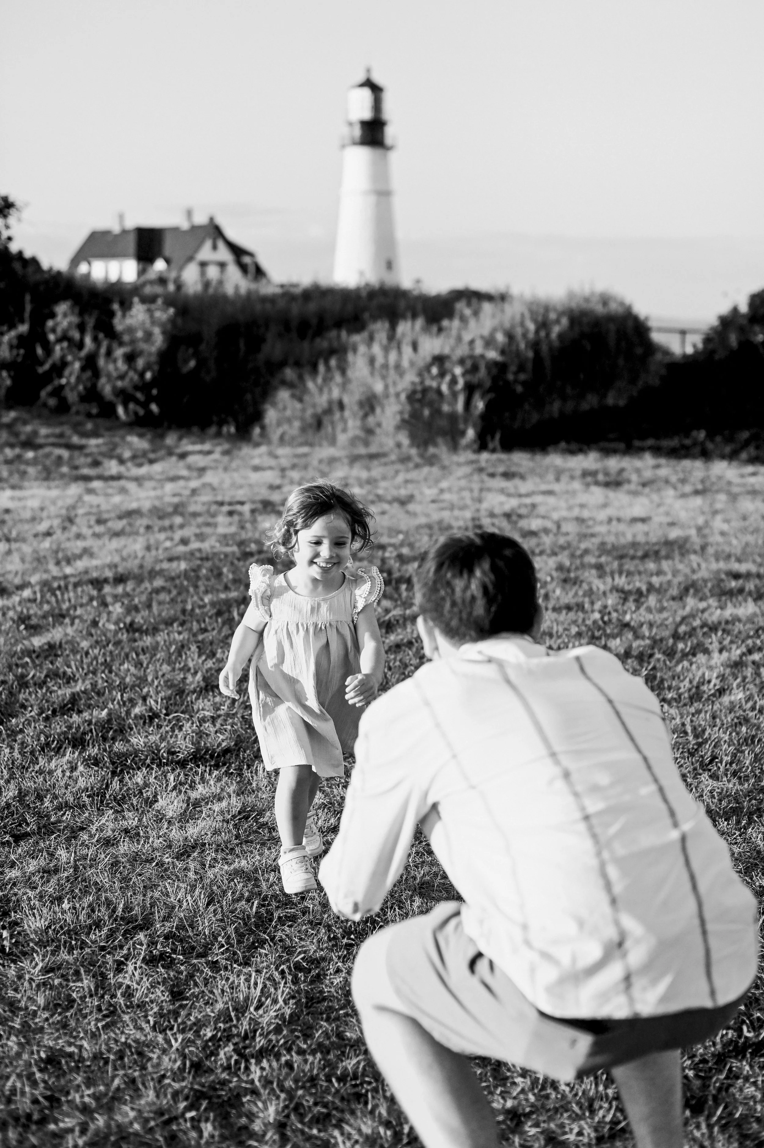 Daughter running towards her father during a candid family session in Maine