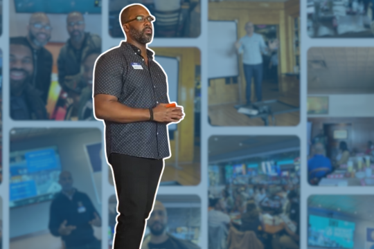 A man holding a cup, standing in front of a collage of various images of people and places.