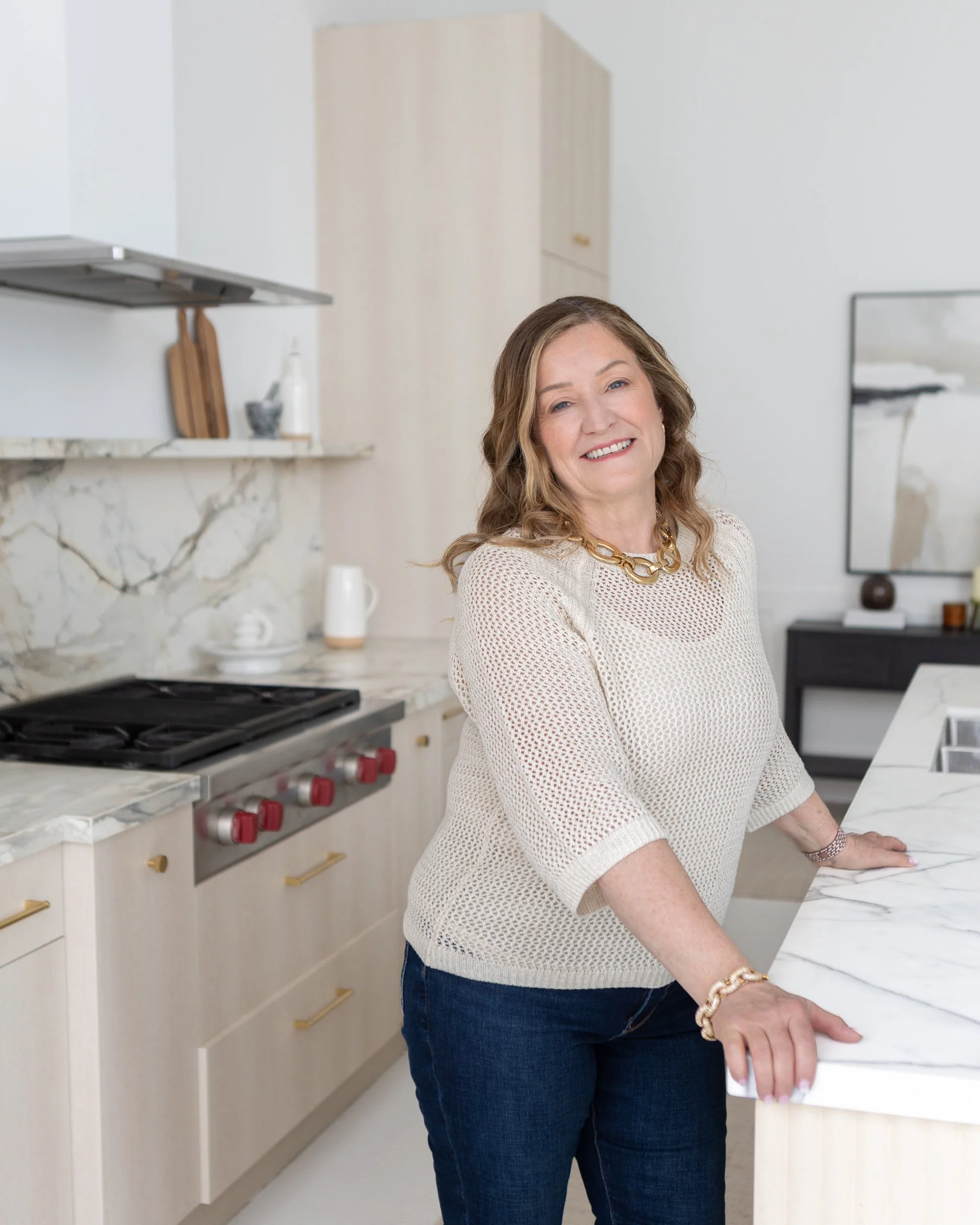 HR Consultant Jo Ann standing at a kitchen island, smiling.
