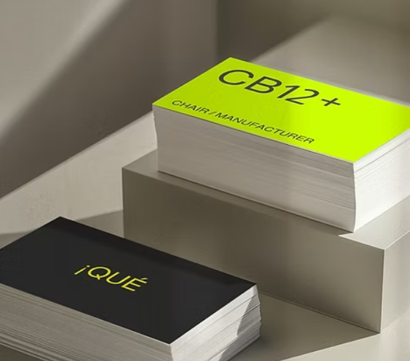 Two stacks of business cards - one black with yellow font and one in yellow with black text that reads "CB12+"