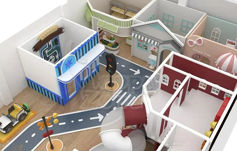A colorful play area designed like a small town with miniature buildings, a road with traffic signs, a crosswalk, and playground equipment.