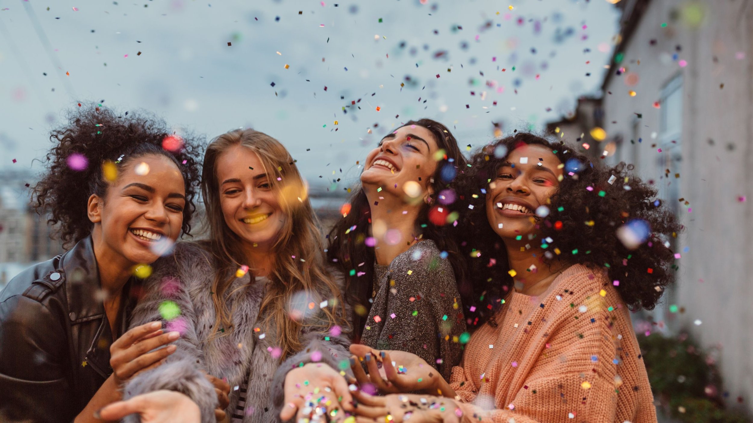 Women outside celebrating with confett.