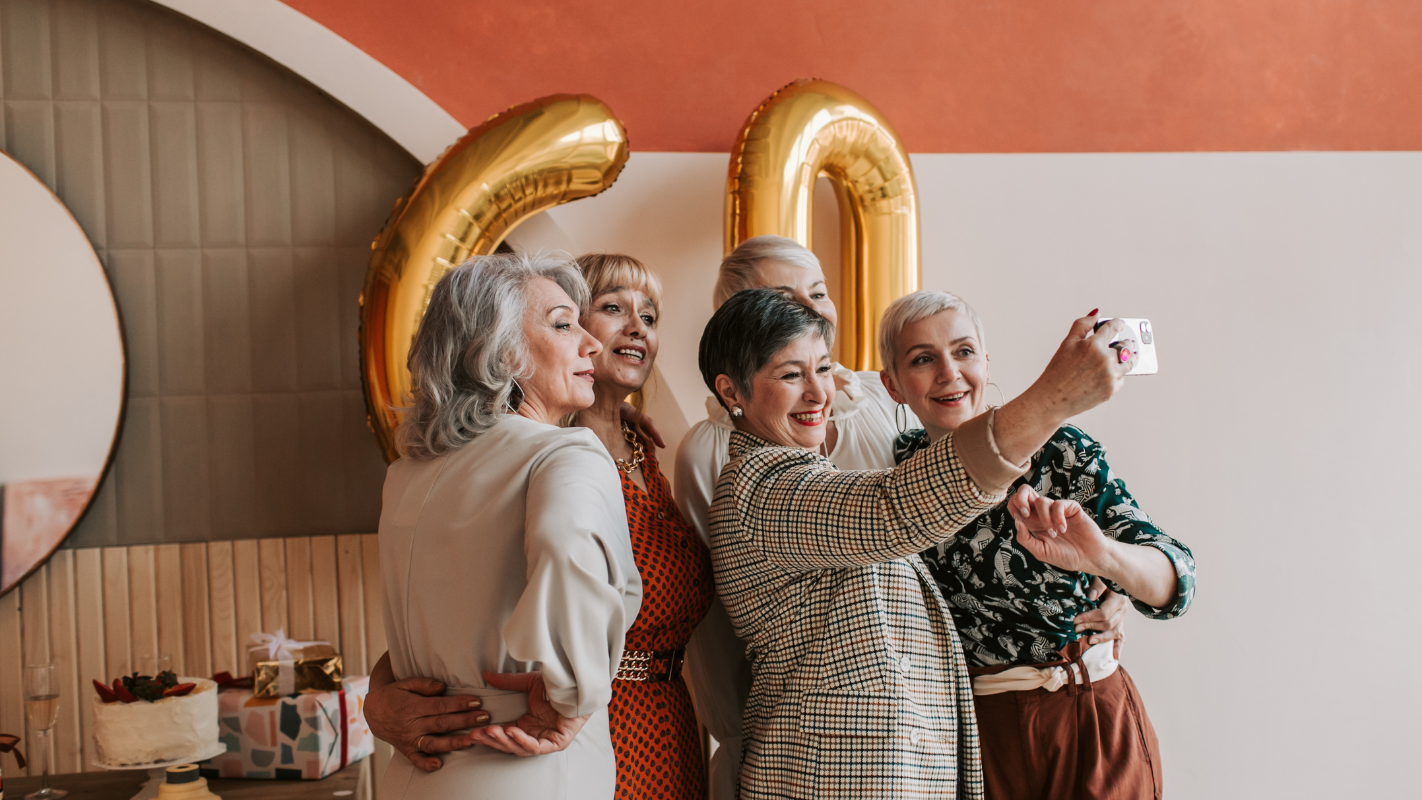 Middle age women who are happy at a party taking a selfie.