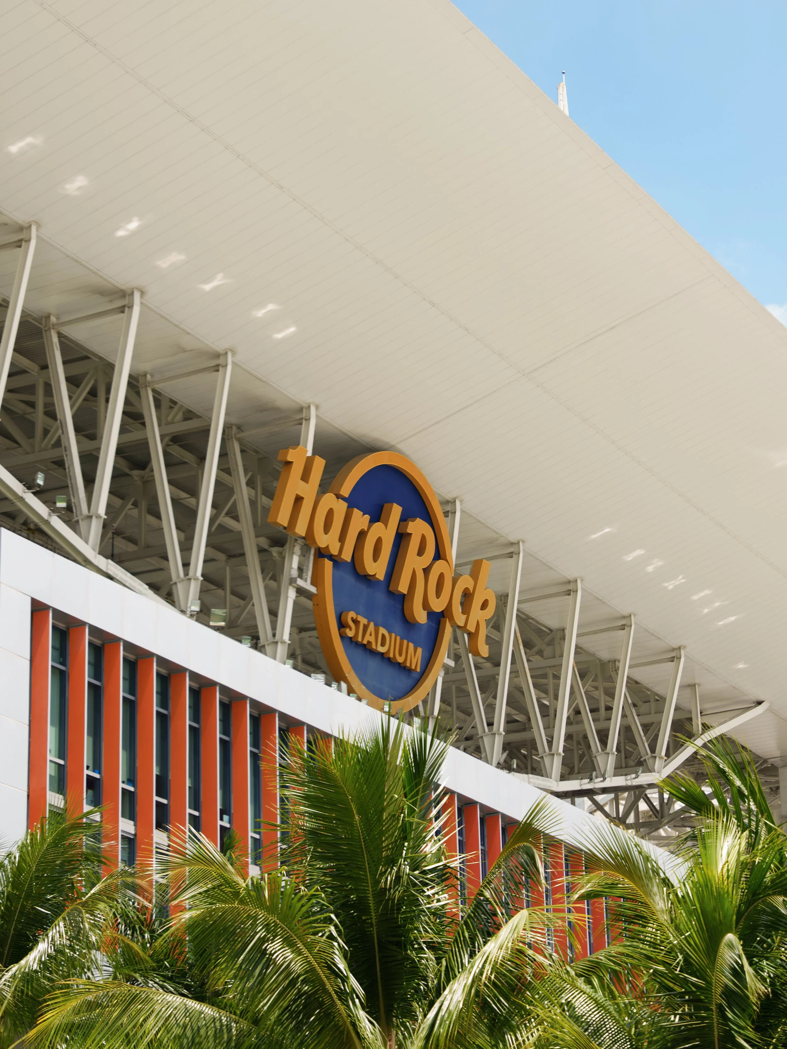Exterior view of Hard Rock Stadium with palm trees in the foreground.