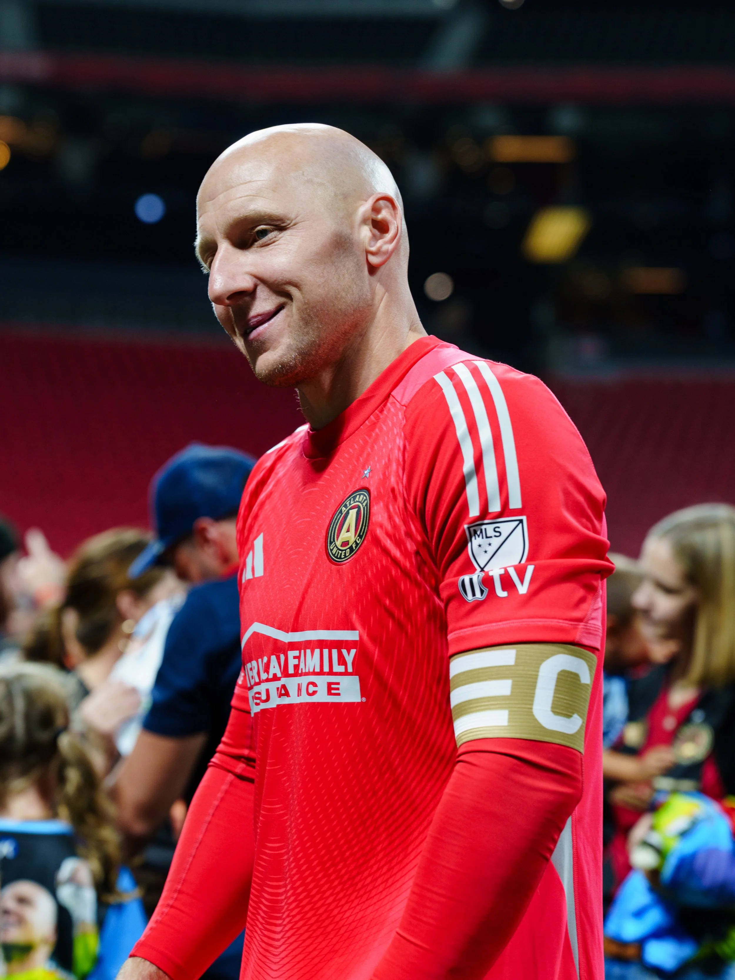 A male soccer player wearing a red jersey with the Atlanta United FC. brad guzan .