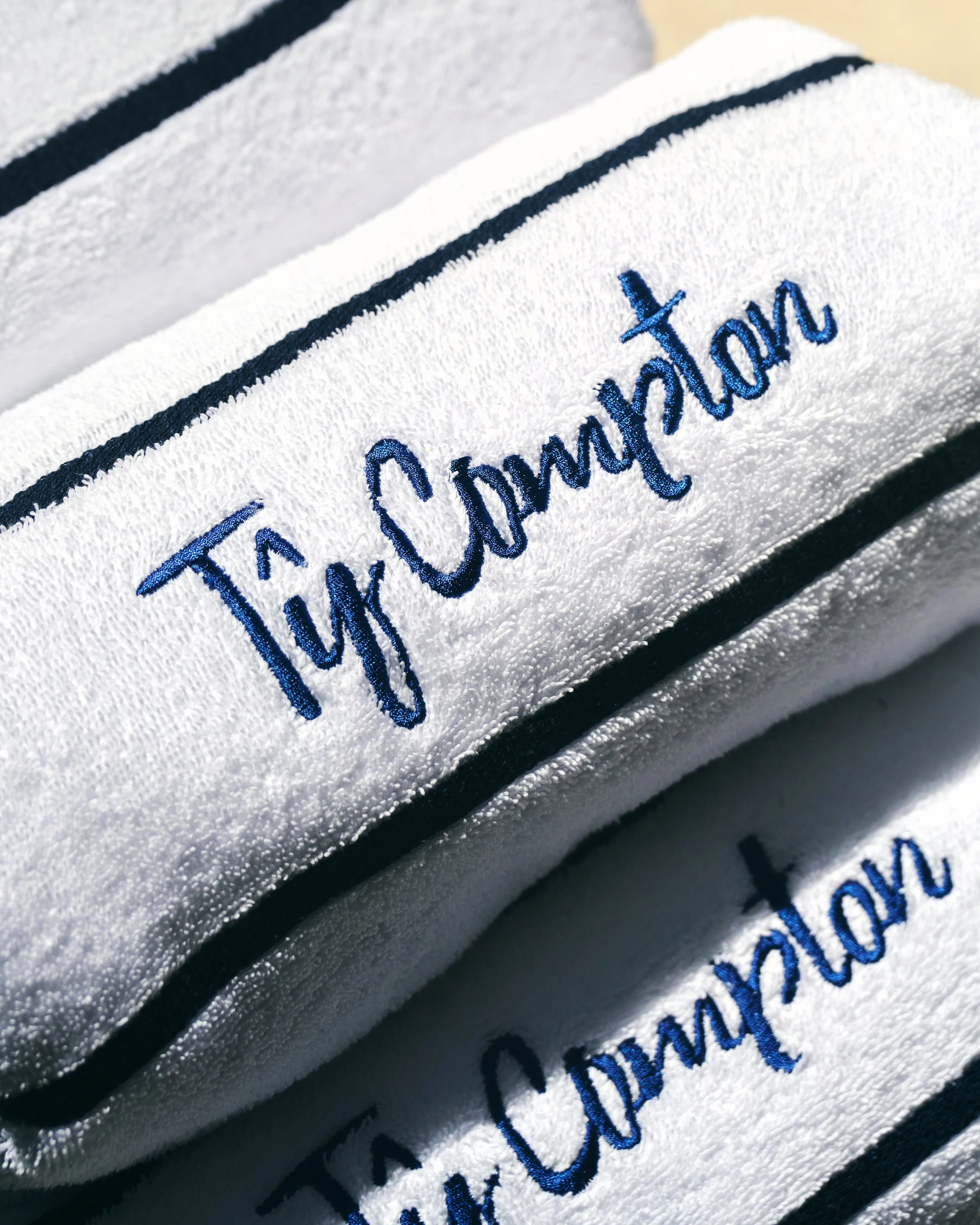 Close-up of white towels embroidered with blue text that says "Try Comfort."