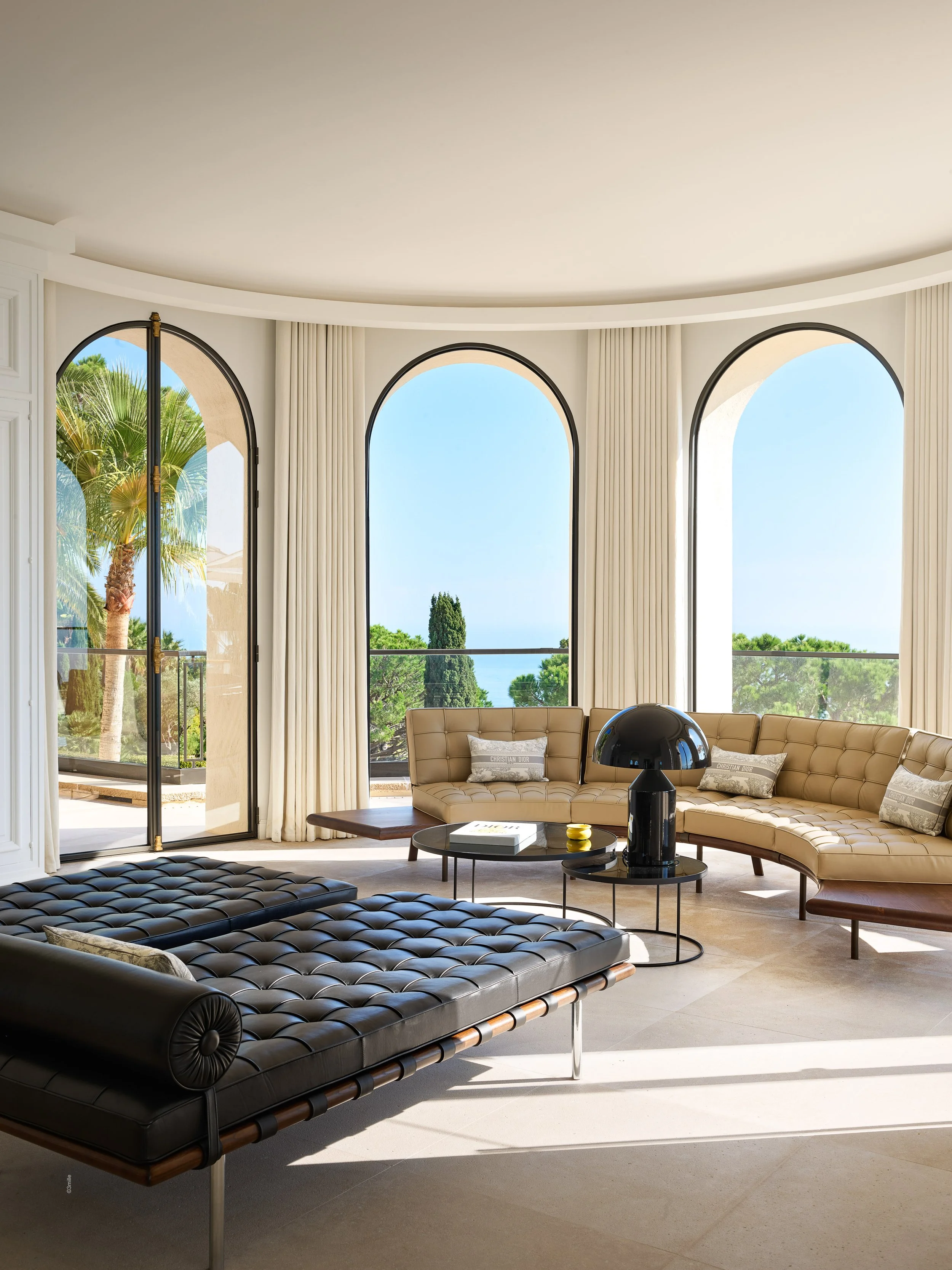 Le salon lumineux de la villa Bagatelle, avec de grandes fenêtres en arches.