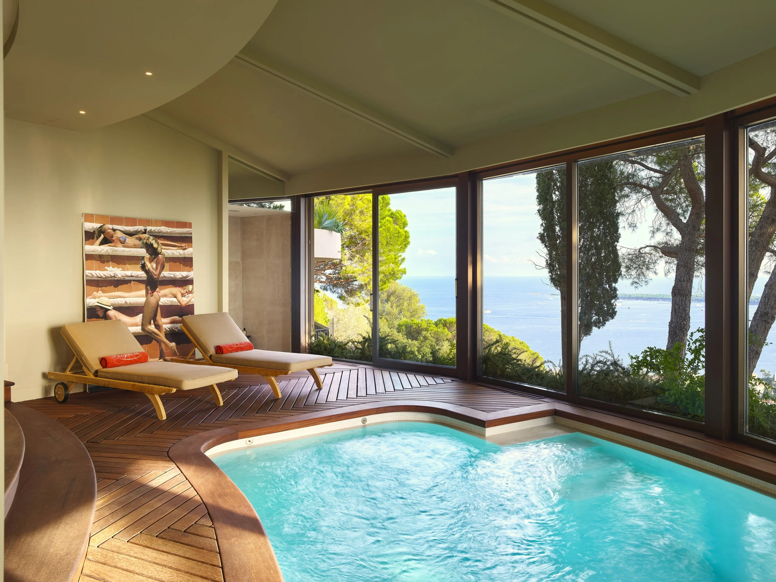 Jacuzzi, deux chaises longues en bois avec des serviettes rouges.
