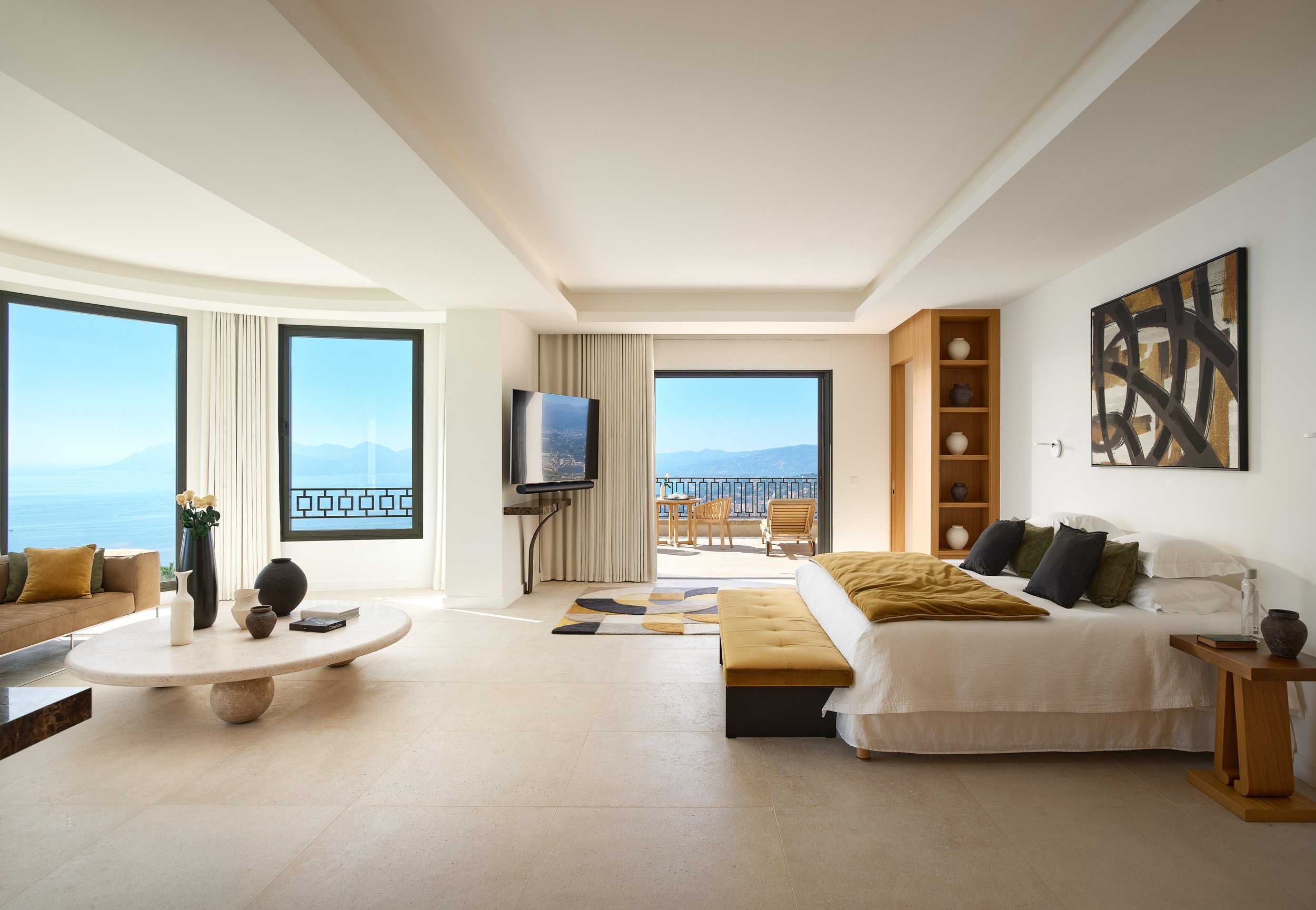 Salon moderne avec grande baie vitrée offrant une vue sur la mer.