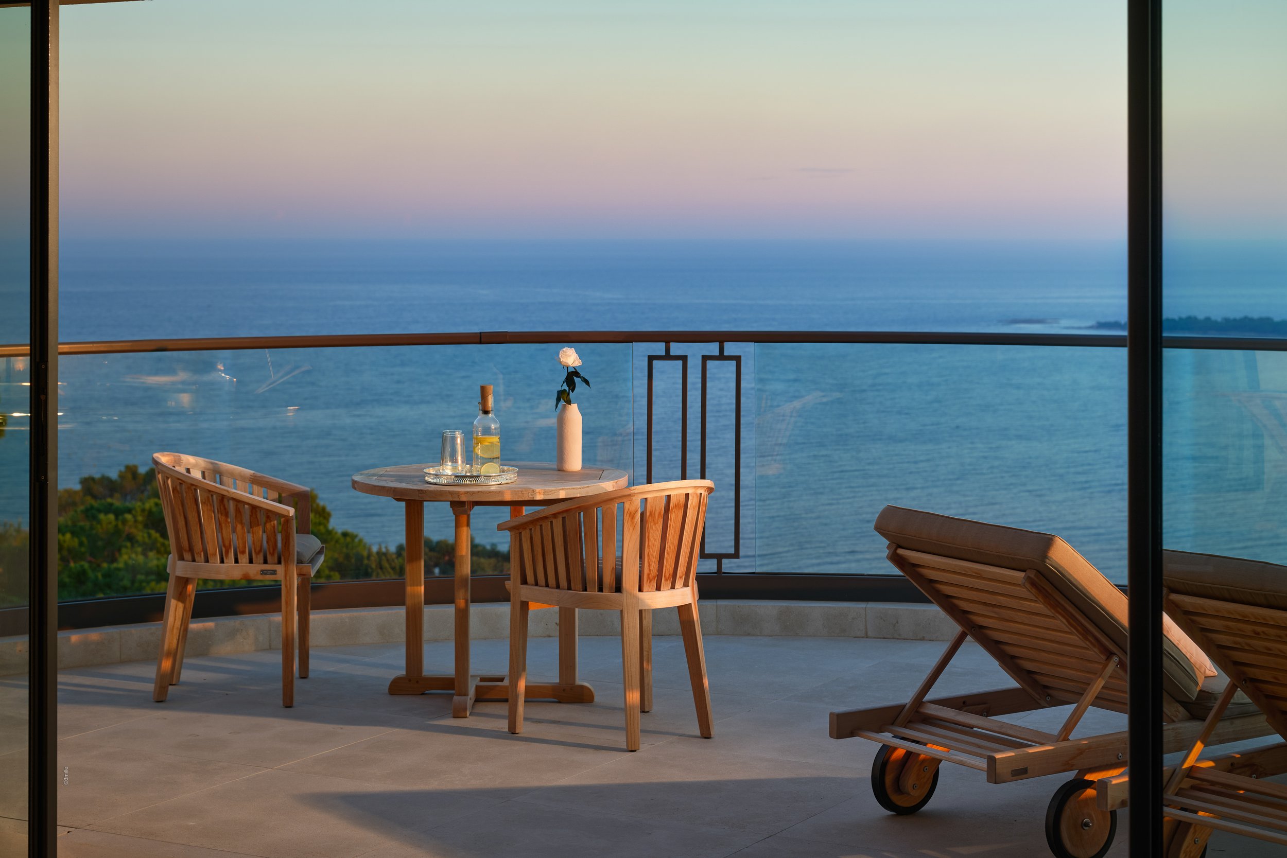 Balcon avec table et chaises en bois.  Villa Bagatelle