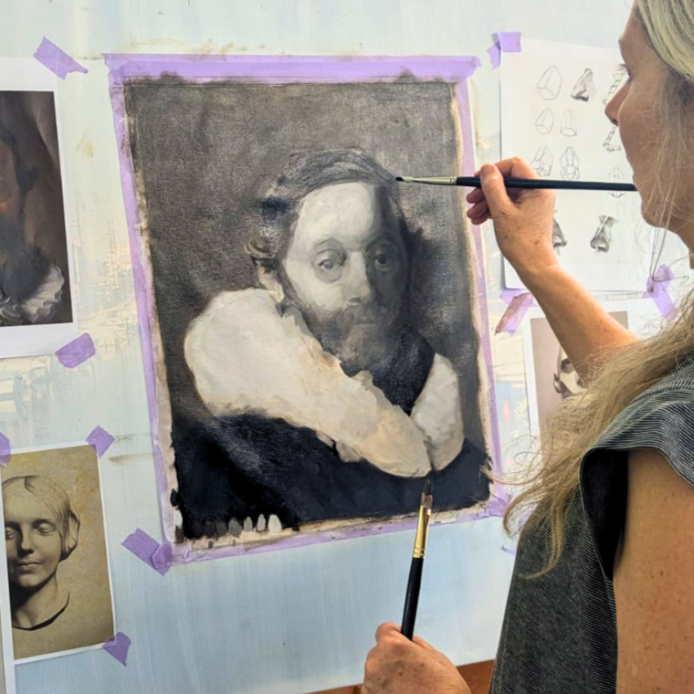 An artist is painting a monochrome portrait of a woman with a ruffled collar on a wall, with sketches and reference photos nearby.
