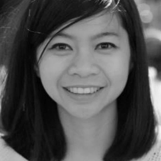 A black and white photo of a smiling young woman with medium-length dark hair and straight teeth.