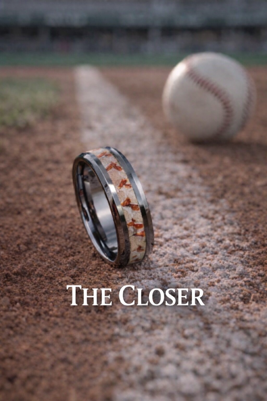 A close-up of a wedding band with real baseball seams, lying on a baseball field's dirt, with a baseball in the background. The text "The Closer" is overlaid on the image.