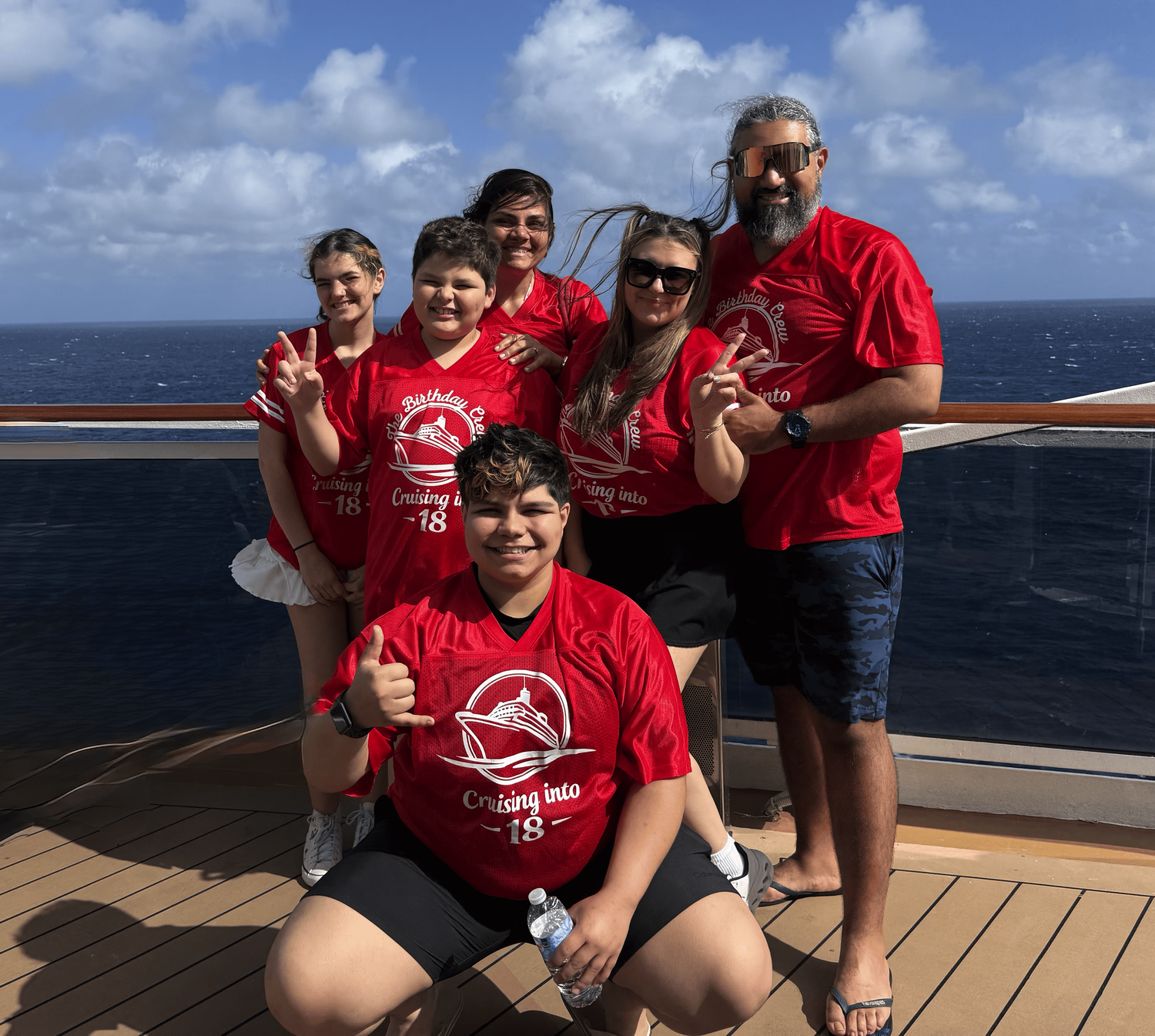 Family in custom red Cruising into 18 jerseys on a cruise deck