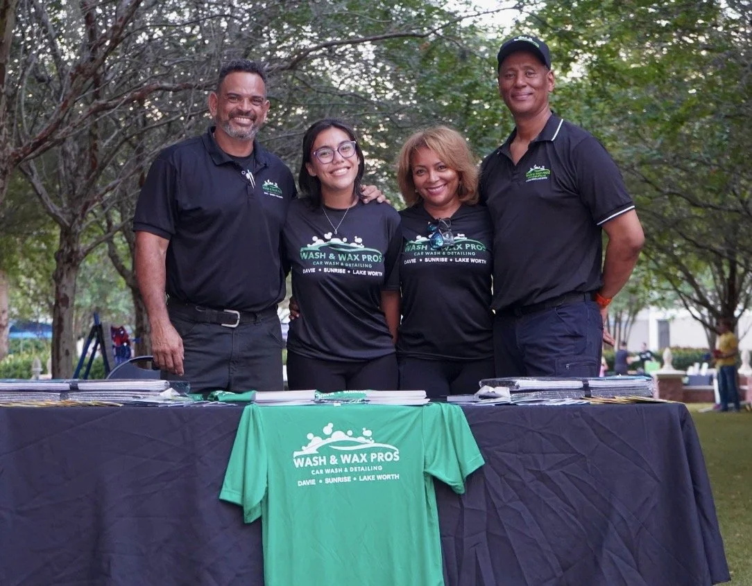 Business team with custom green tees and table cover at an event