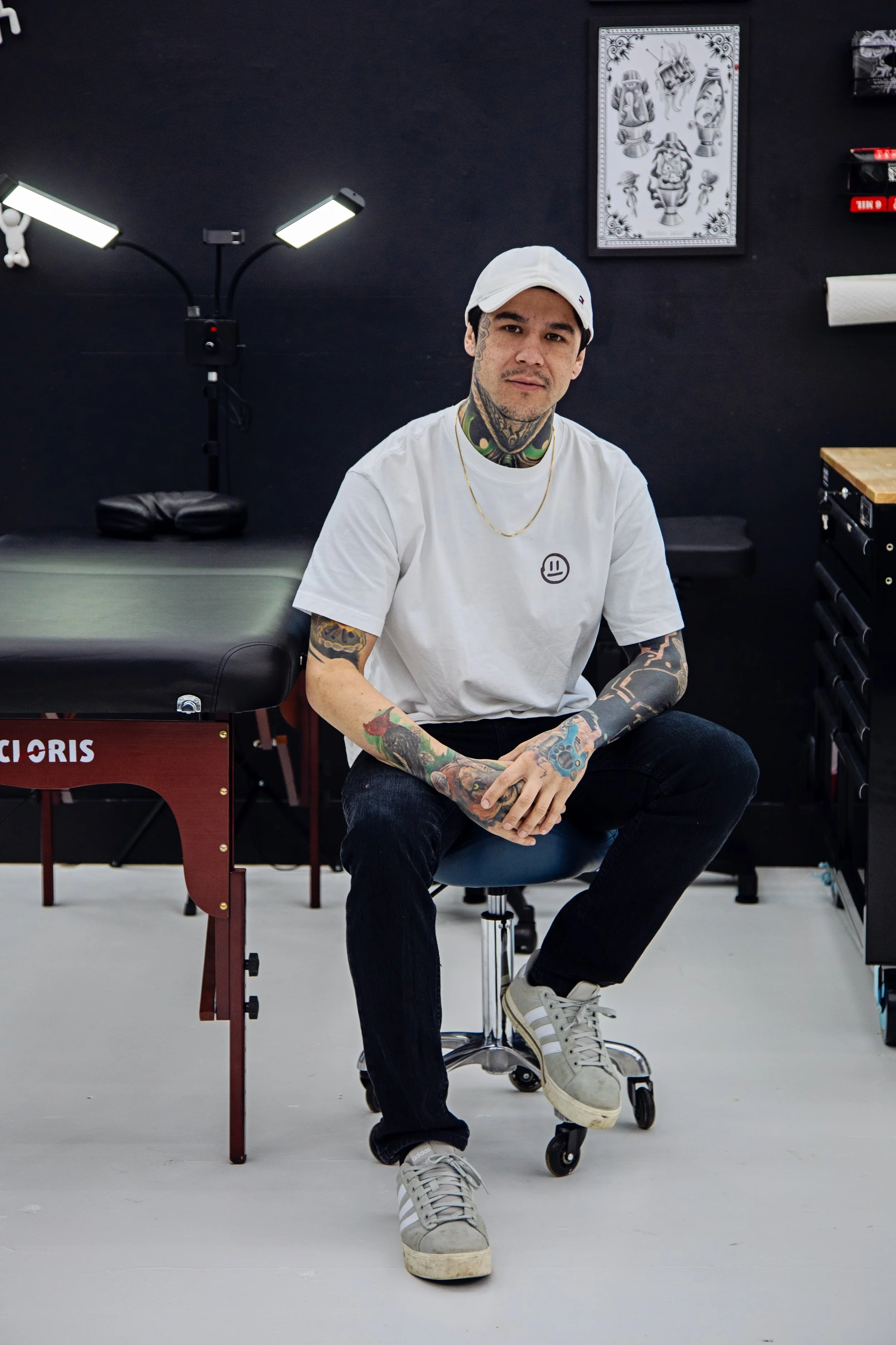 A detailed black and white illustration of a fierce demon or oni mask with elaborate traditional Japanese design, including prominent horns, sharp teeth, and ornate floral decorations.