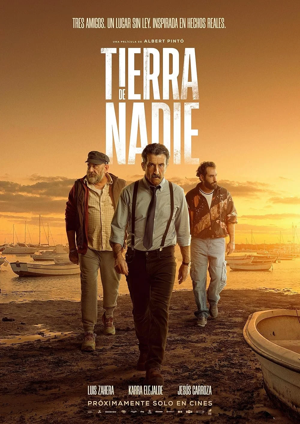 Movie poster for 'Tierra de Nadie' featuring three men walking along a dock at sunset with boats in the background. The title is in large white letters at the top.