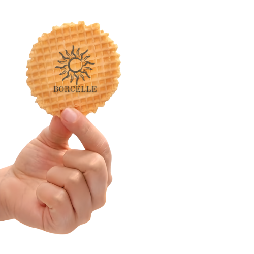 A hand holding a round waffle with a logo of a sun and the word 'BORCELLE' printed on it.