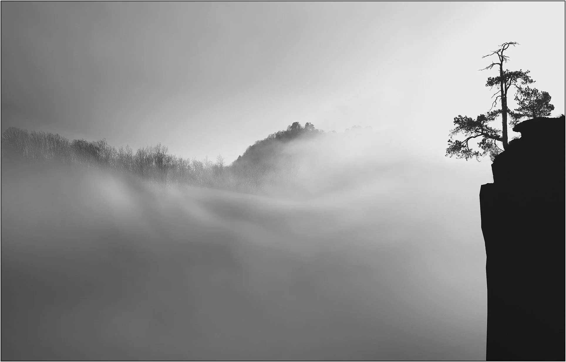 Sandstone mountains emerging through drifting mist and clouds in Zhangjiajie, China.