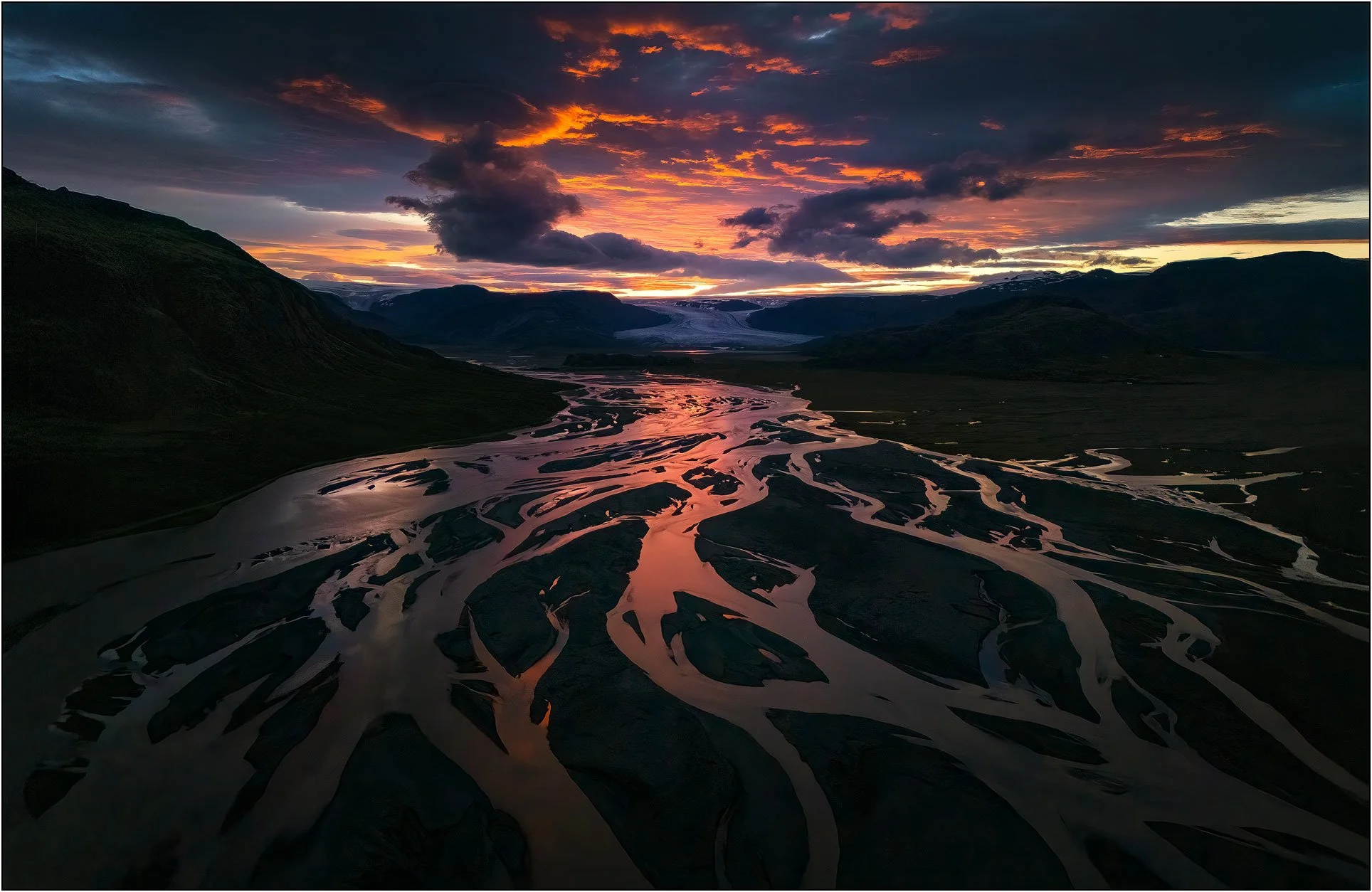Blazing sunset with burning clouds at a glacier river, Iceland.