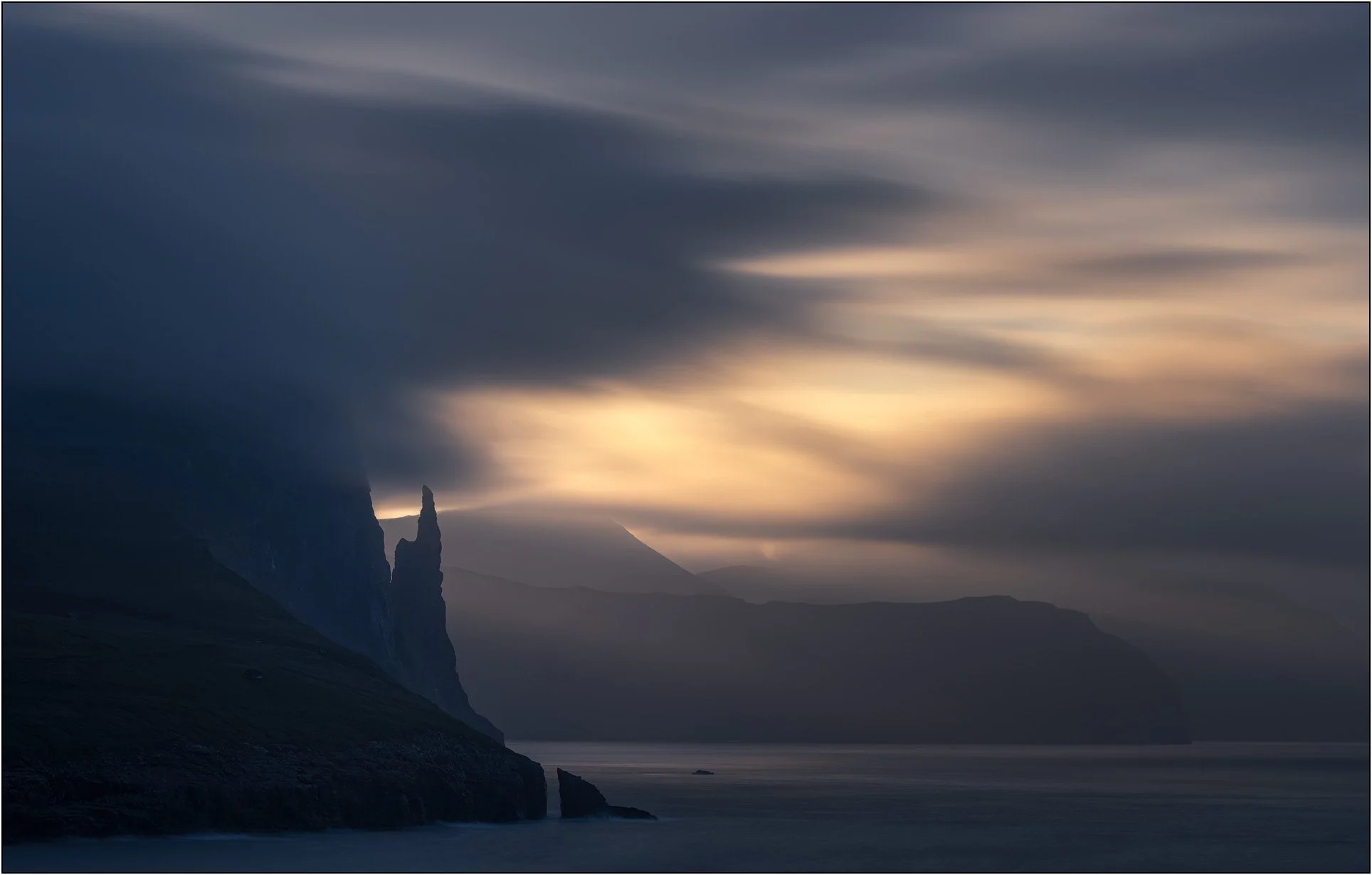 Long exposure clouds flowing over mountains and fjords at Witch's finger, Faroe Islands.