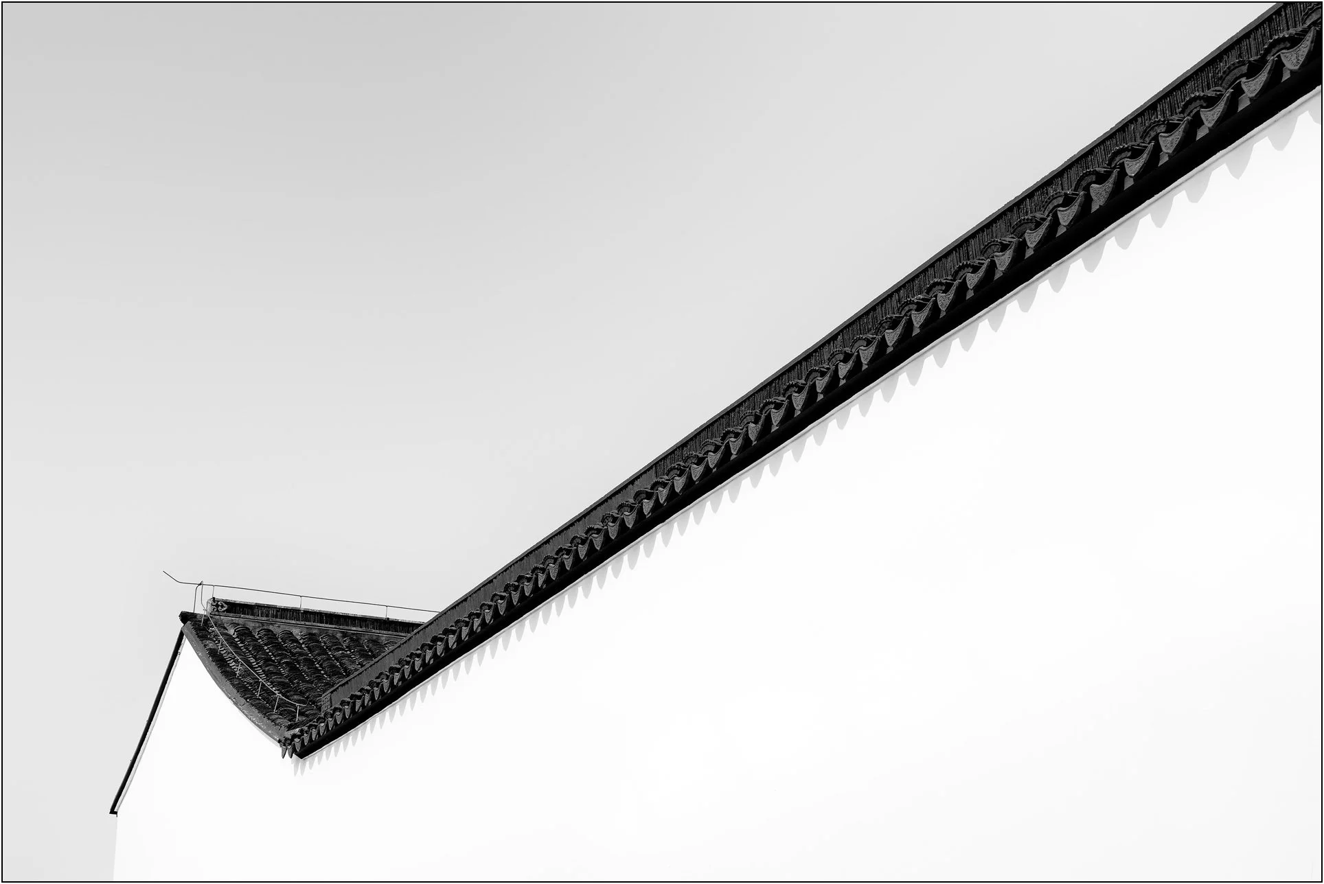 Black and white image of a traditional Chinese roofline with clean minimal composition, Suzhou museum, China.