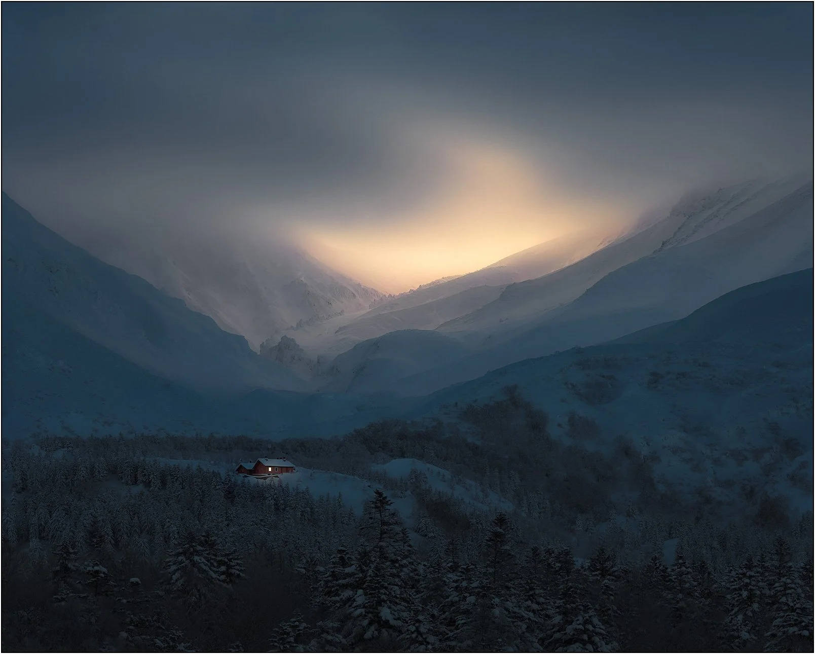 Snow-covered valley at sunrise with a small cabin glowing among trees beneath misty mountains in Hokkaido, Japan.