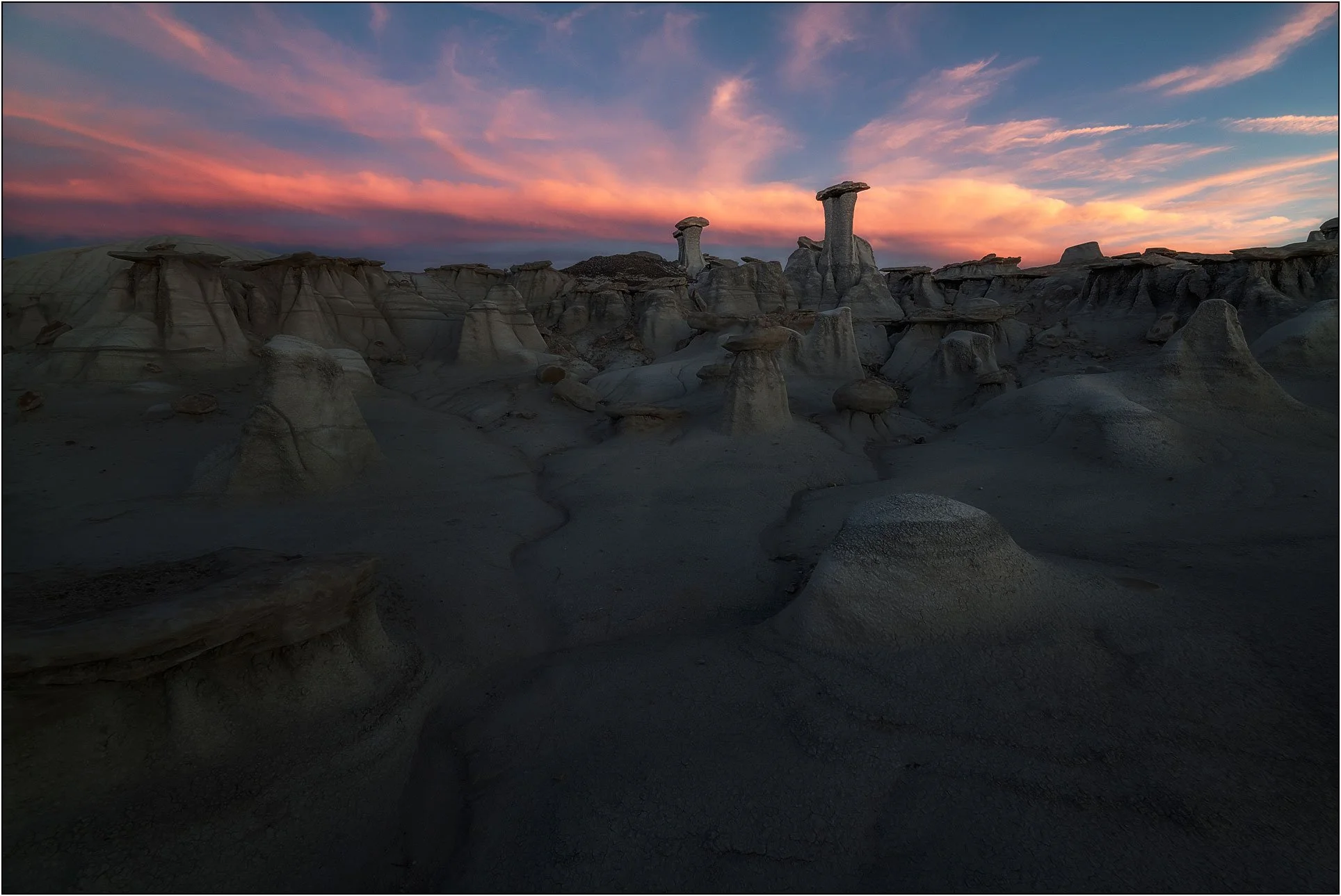 Badlands hoodoos under a dramatic sunset sky
