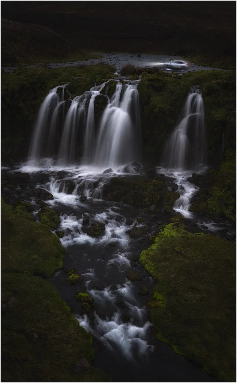 Explorer drives car over waterfall in highland Iceland.