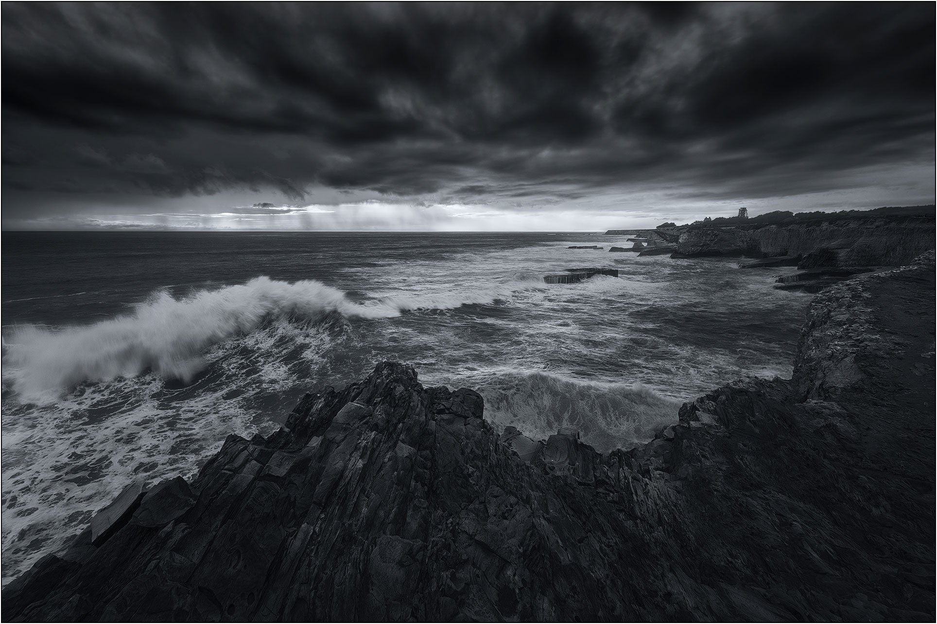 Storm waves crashing against rugged coastline under dramatic skies