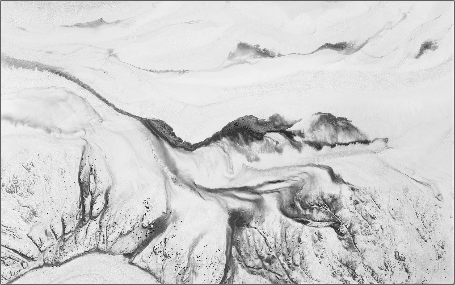 Aerial abstraction of a tailings lake with flowing monochrome forms resembling ink wash patterns