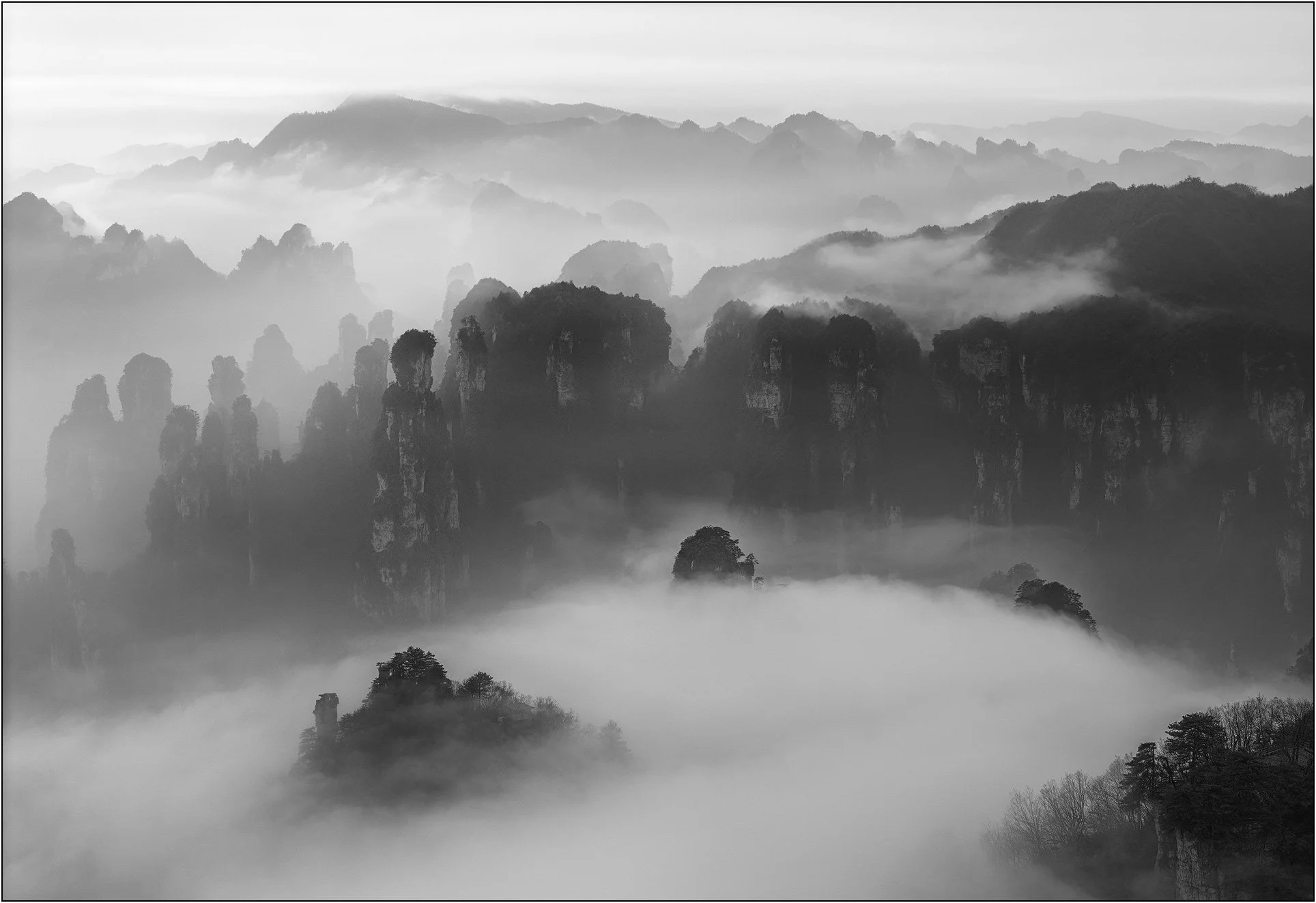 Sandstone mountains emerging through drifting mist and clouds in Zhangjiajie, China.