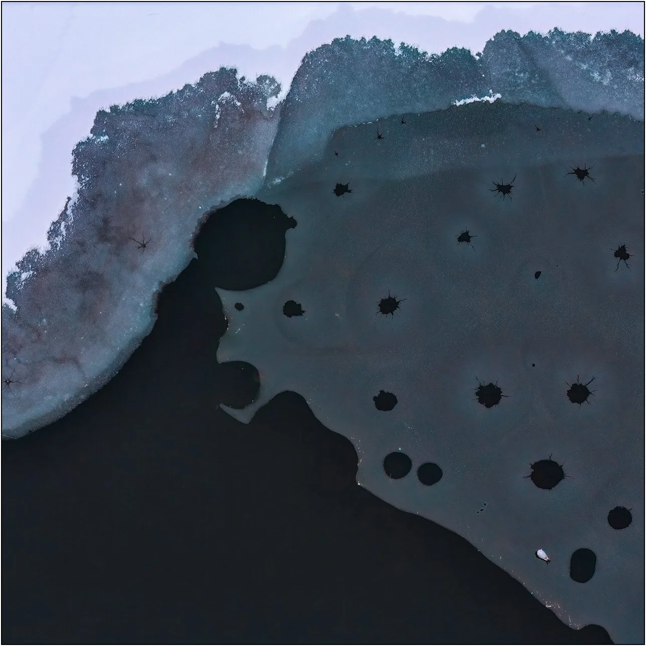 Aerial abstract view of dark circular voids scattered across a textured surface