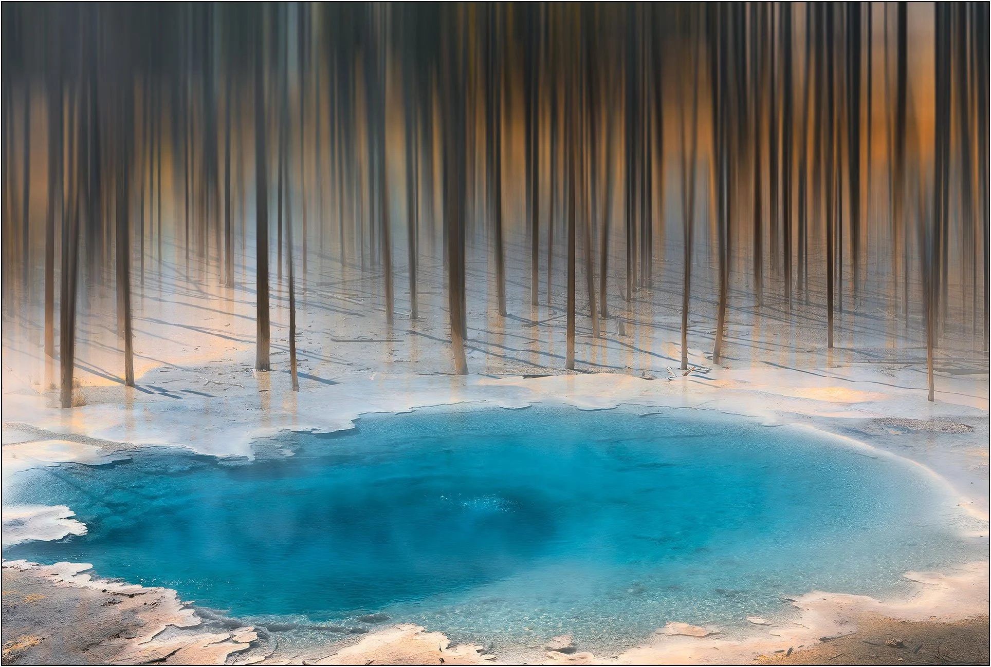 Abstract impression of blue hot spring pool with blurred forest reflections in Yellowstone