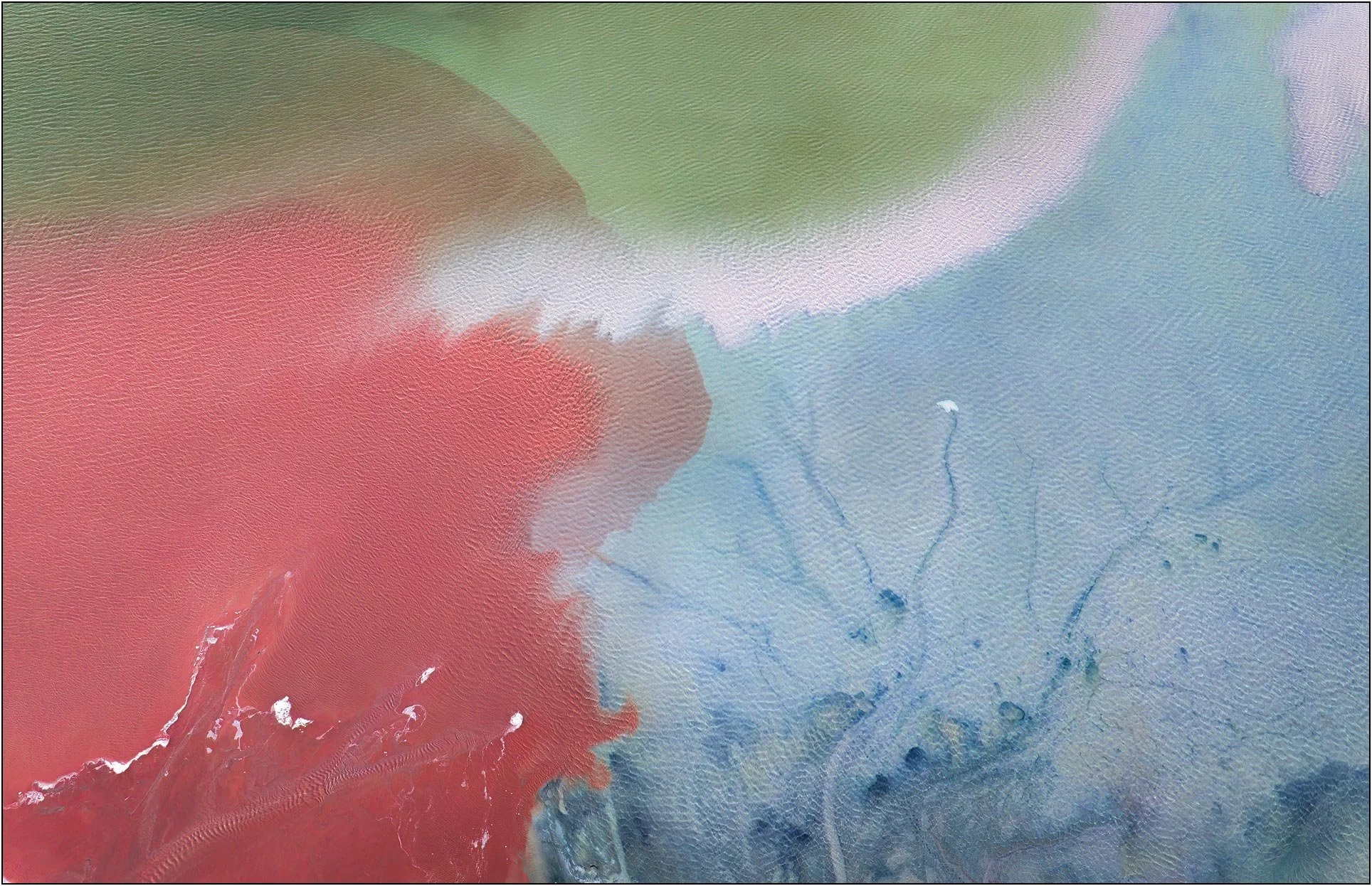 Aerial view of a tailings lake with soft color gradients blending red, blue, and green tones
