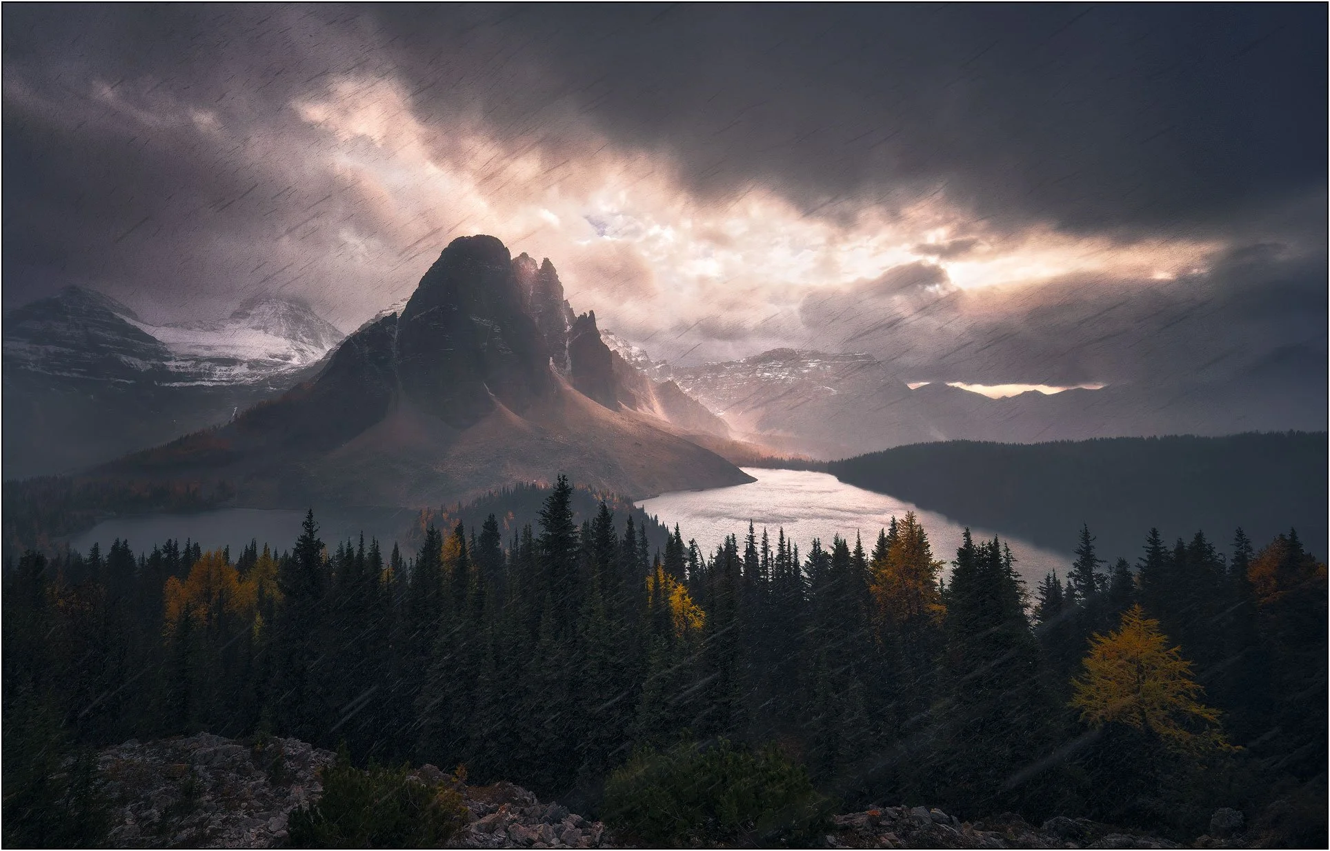 Mt. Assiniboine in blizzard, dramatic light through clouds.