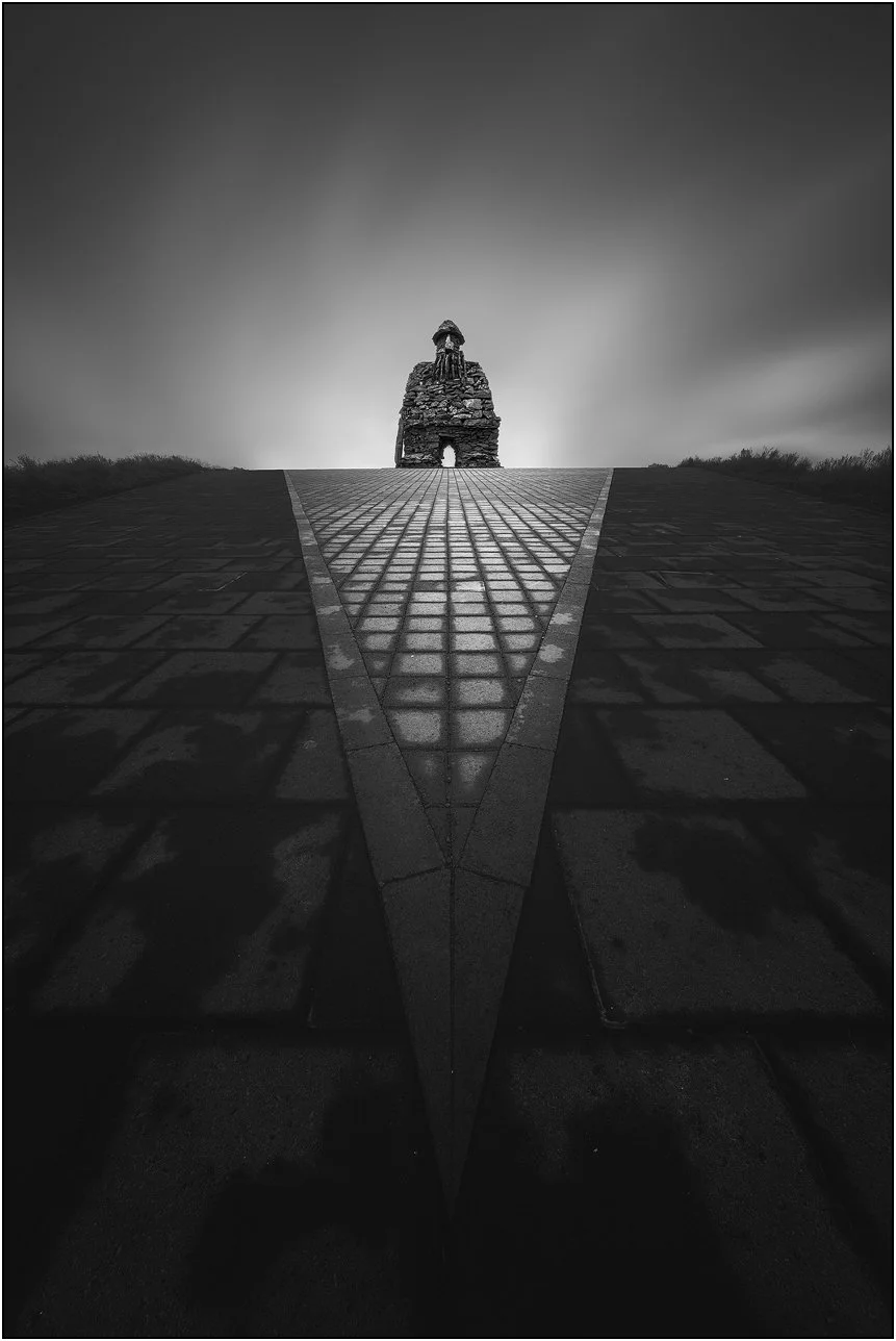 Black and white image of a statue Bárður Saga Snæfellsás in Iceland, with soft long exposure sky and triangle shaped foreground.