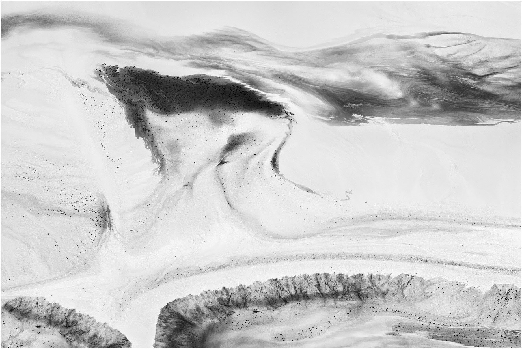 Aerial abstraction of a tailings lake with minimal black and white tones evoking a quiet ink landscape