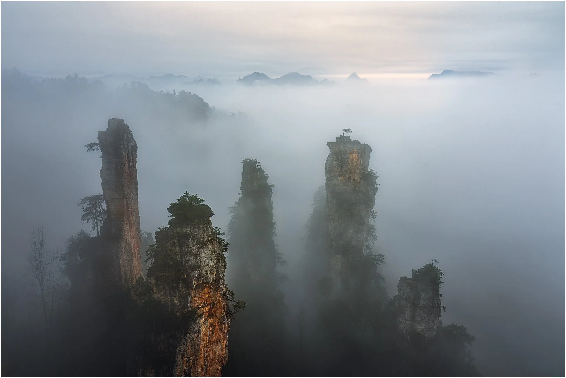 Sandstone mountains emerging through drifting mist and clouds in Zhangjiajie, China.