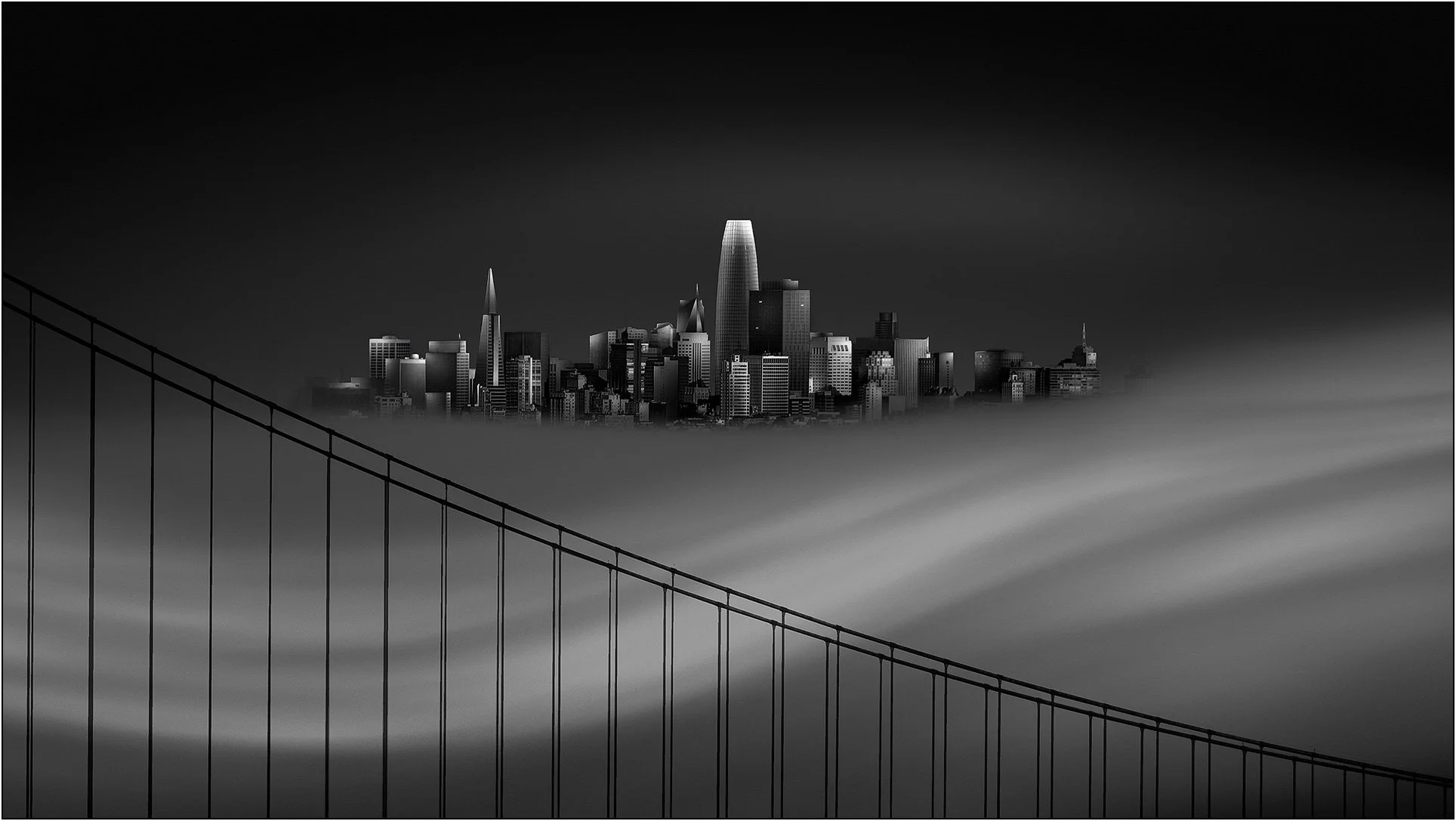 San Francisco skyline emerging above drifting fog with bridge lines