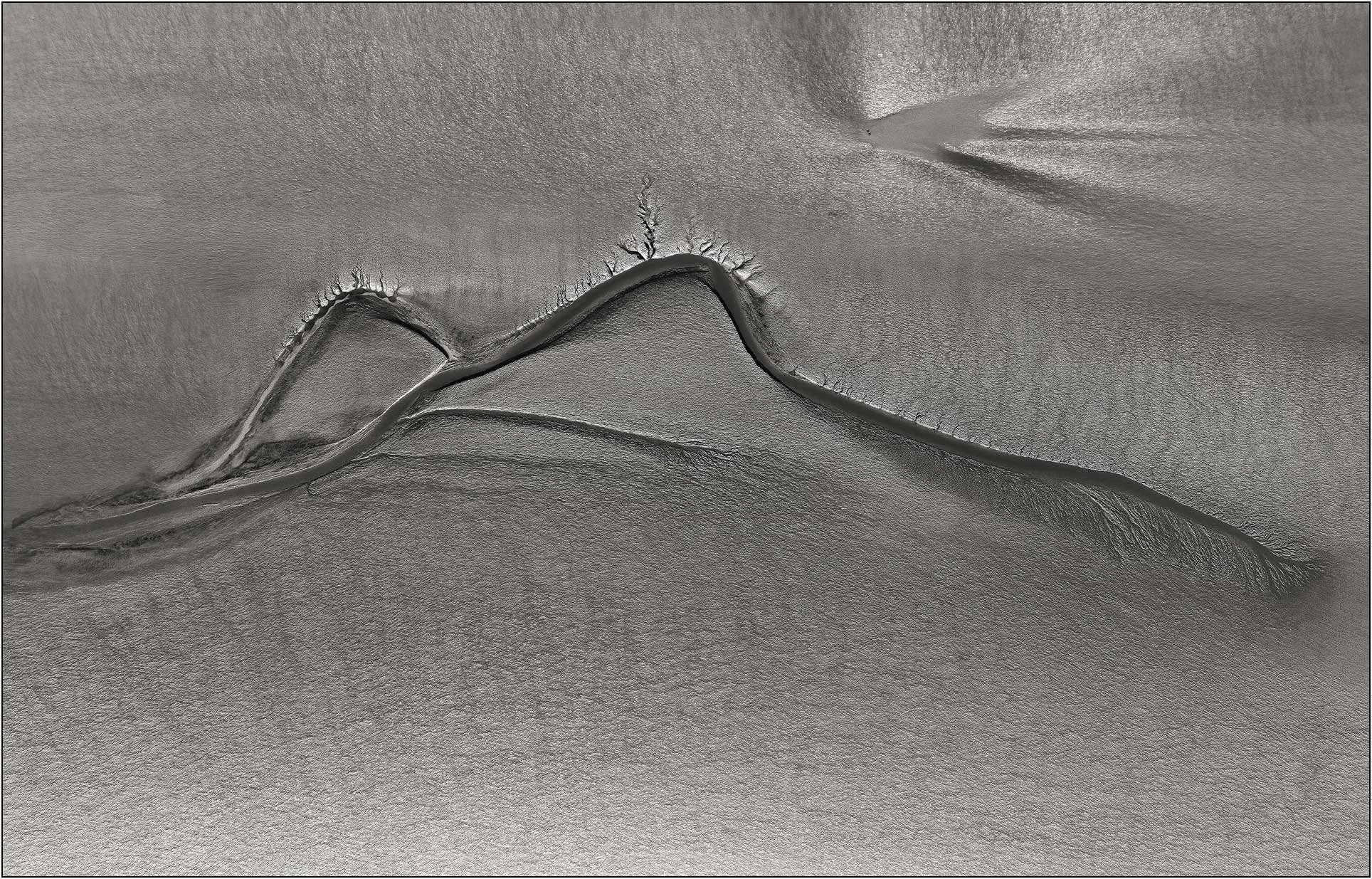 Minimalist aerial abstraction with smooth tonal gradients and a single flowing tidal form