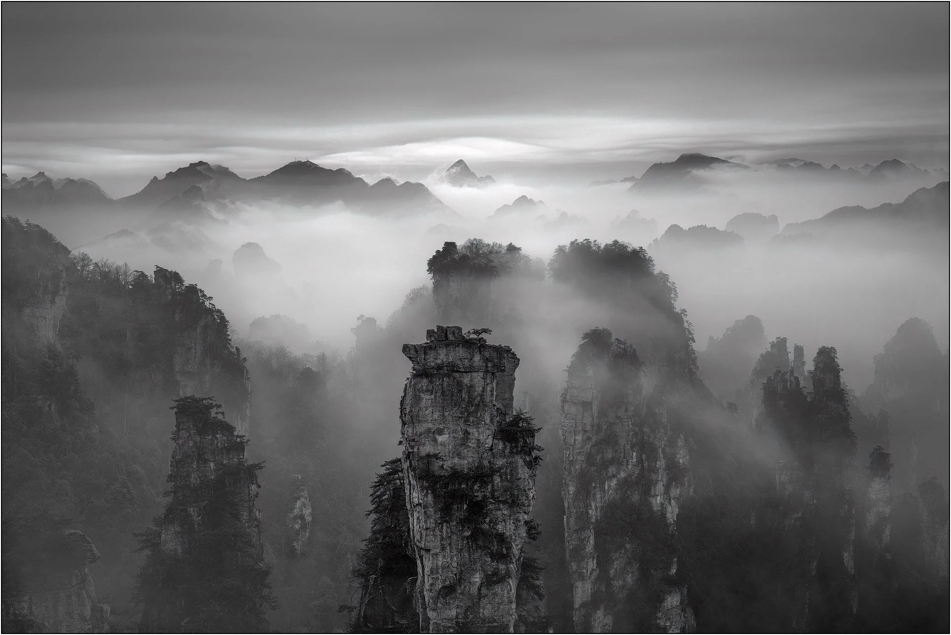 Sandstone mountains emerging through drifting mist and clouds in Zhangjiajie, China.