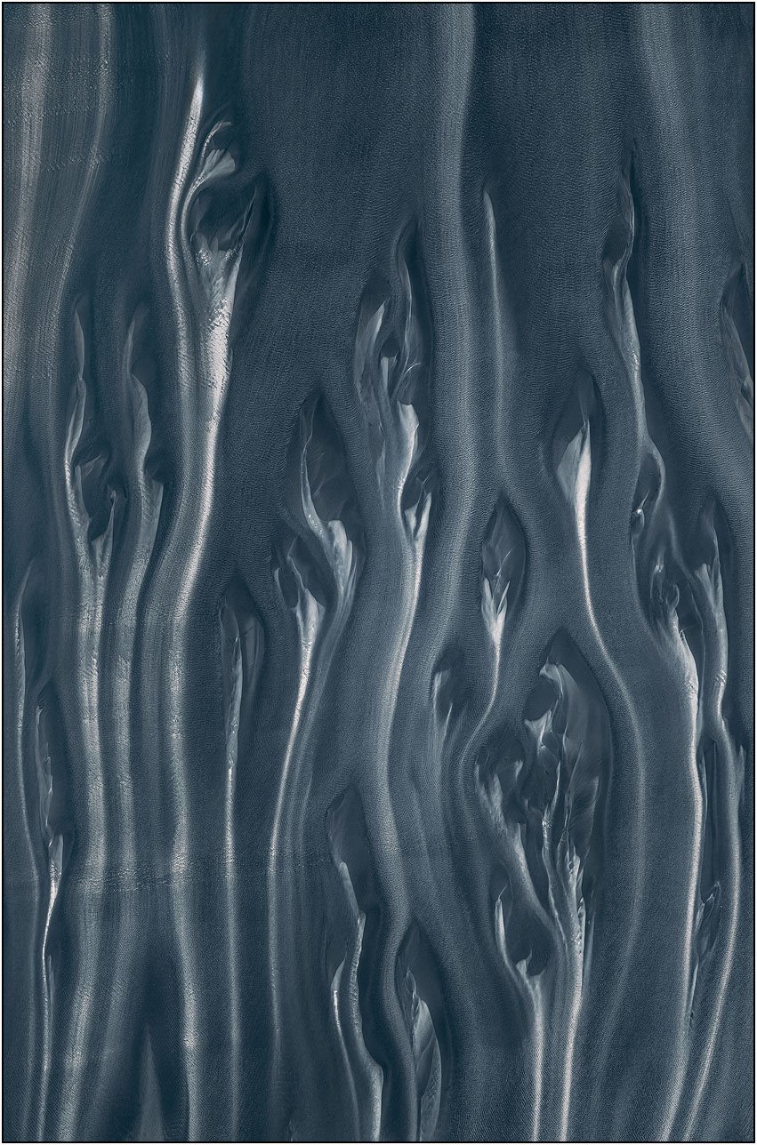 Abstract aerial composition with elongated flowing forms and smooth, sculptural textures