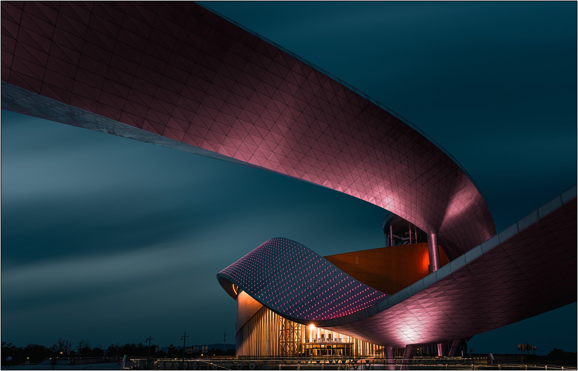 Suzhou Bay Grand Theatre in China at night, with futuristic curved architecture and lighting.