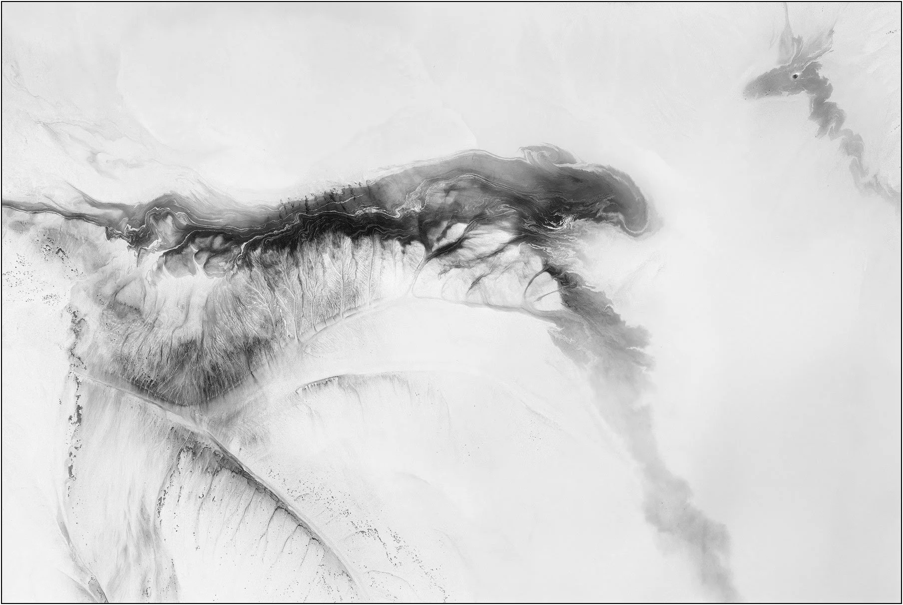 Aerial abstraction of a tailings lake with a sweeping dark band dissolving into soft tonal gradients
