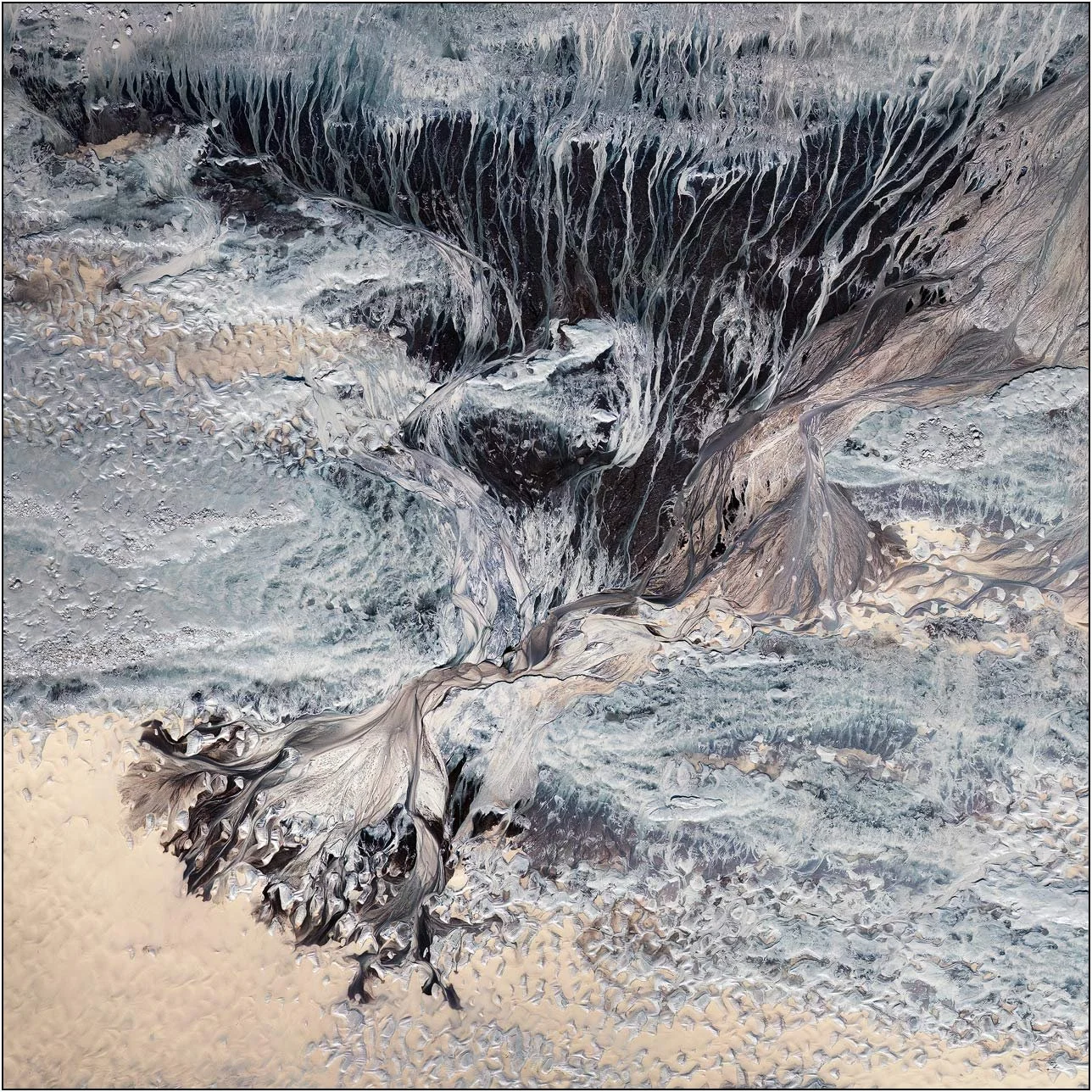 Fine art aerial photography of the Qiantang River tidal flats in China, revealing a maze of erosion channels, rippled sand, and layered sediment shaped by the tides. Seen from above, these intricate formations resemble a miniature world of cliffs, va